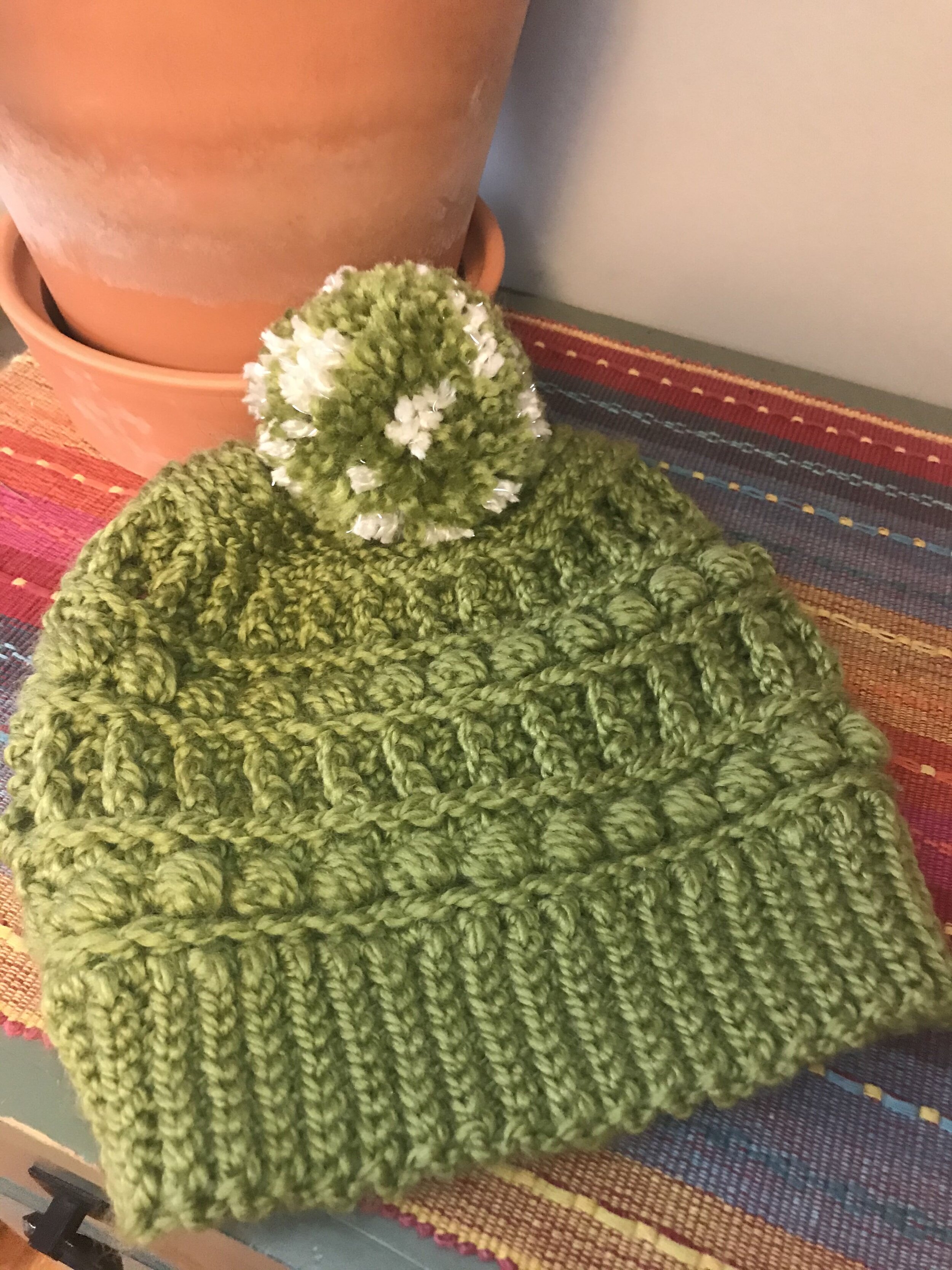 Green knit toque with pompom