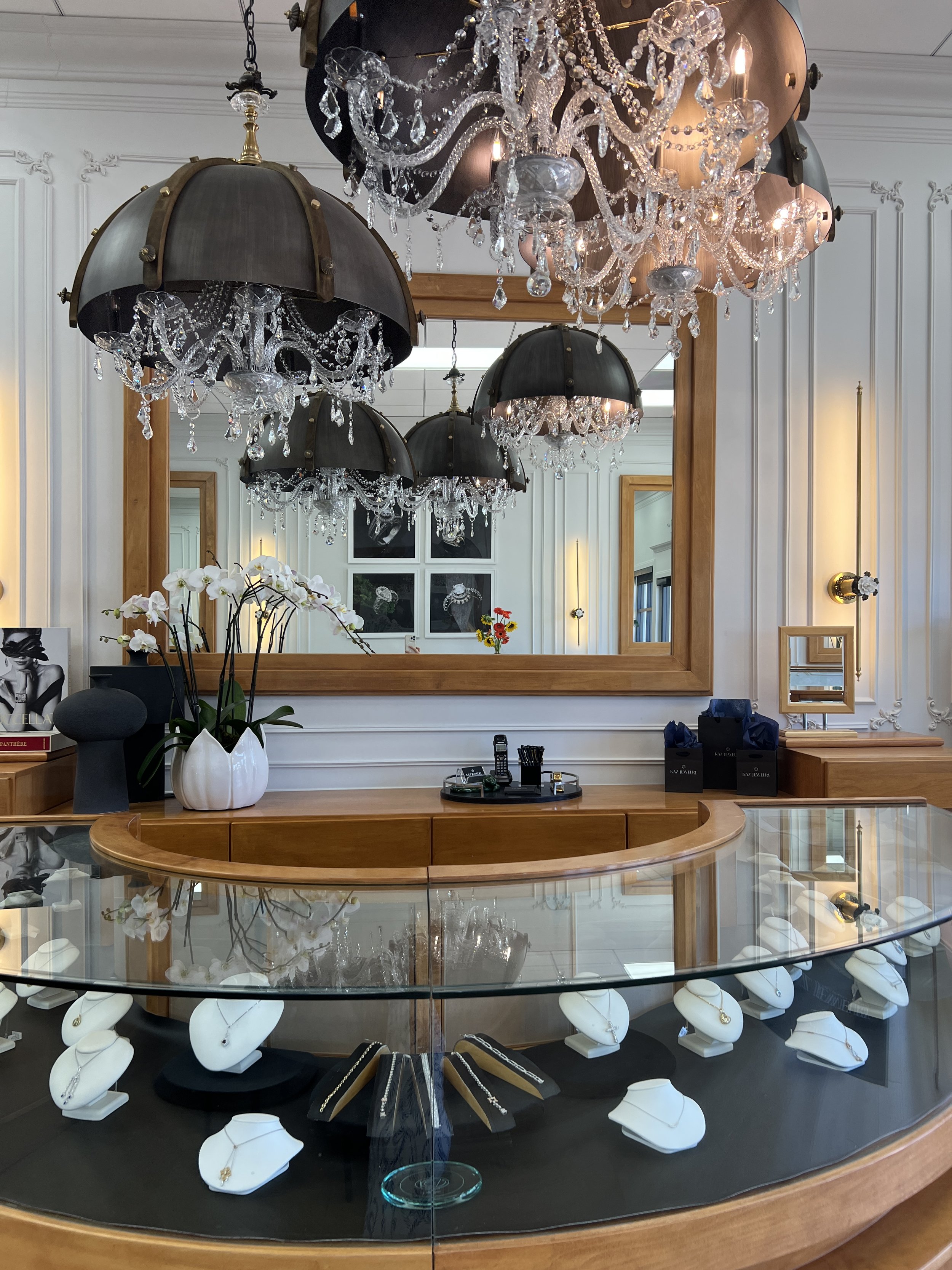 Kaz Jewelry boutique in Laguna Niguel with jellyfish dome chandeliers, applied wall moldings and display cases, interior design by LUXYSPACE