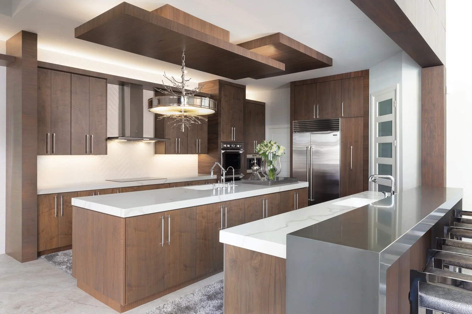 Open modern kitchen with wood cabinetry and sculptural chandelier, LUXYSPACE kitchen design