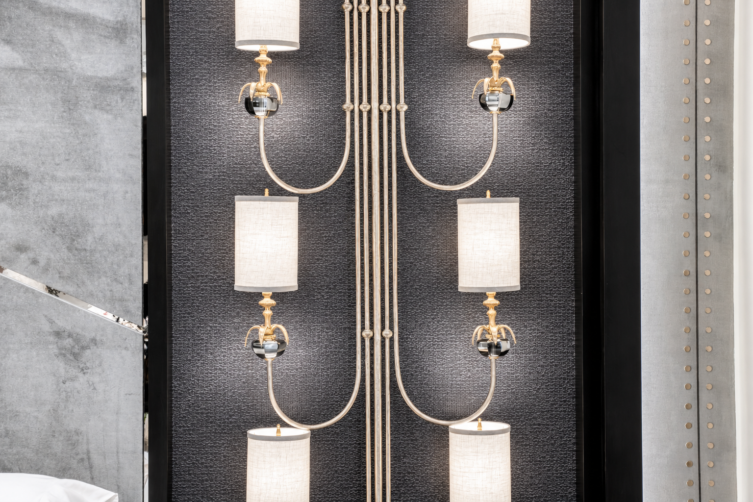 Gold and black wall sconces on a dark textured wall, custom lighting design by LUXYSPACE