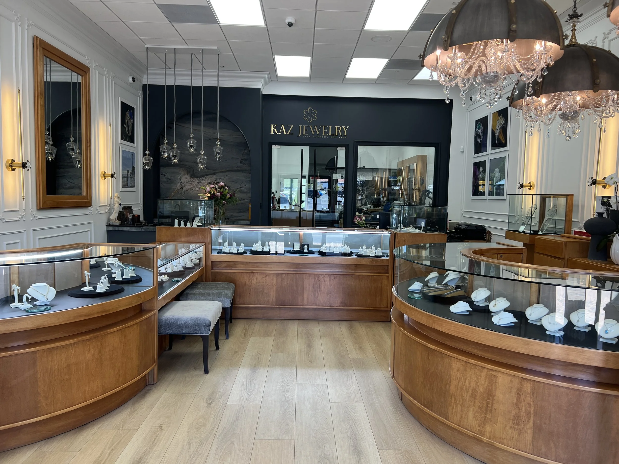 Kaz Jewelry Laguna Niguel showroom with color-drenched charcoal feature wall, signage and glass workshop view