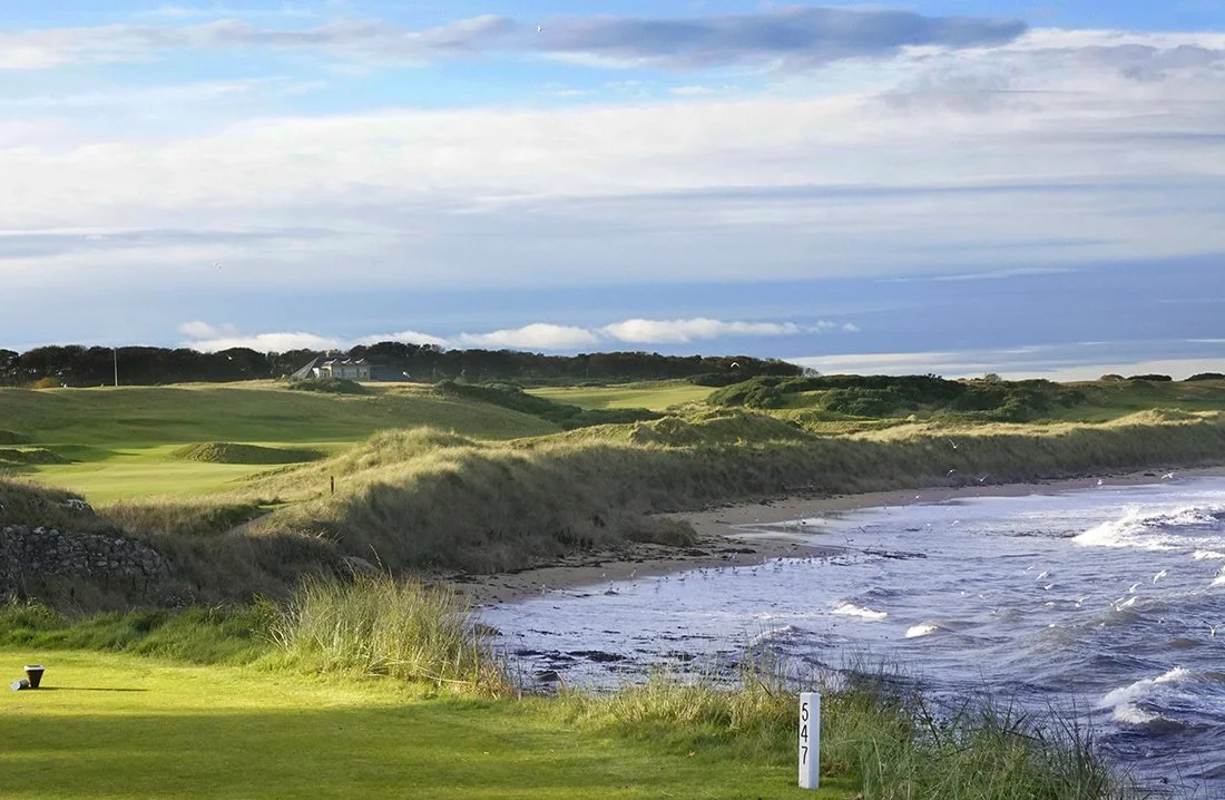 A stunning view of the rolling green fairways running alongside the ocean and sandy beach at Kingsbarns Golf Links, a premier coastal course featured on our luxury escorted golf tours to Scotland The Home Of Golf.