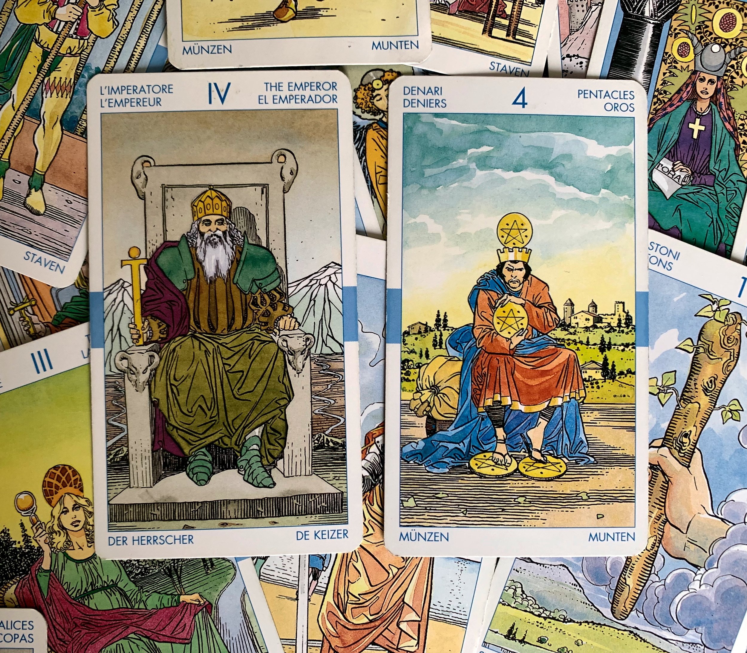 emperor and four of pentacles are on top of a pile of other tarot cards