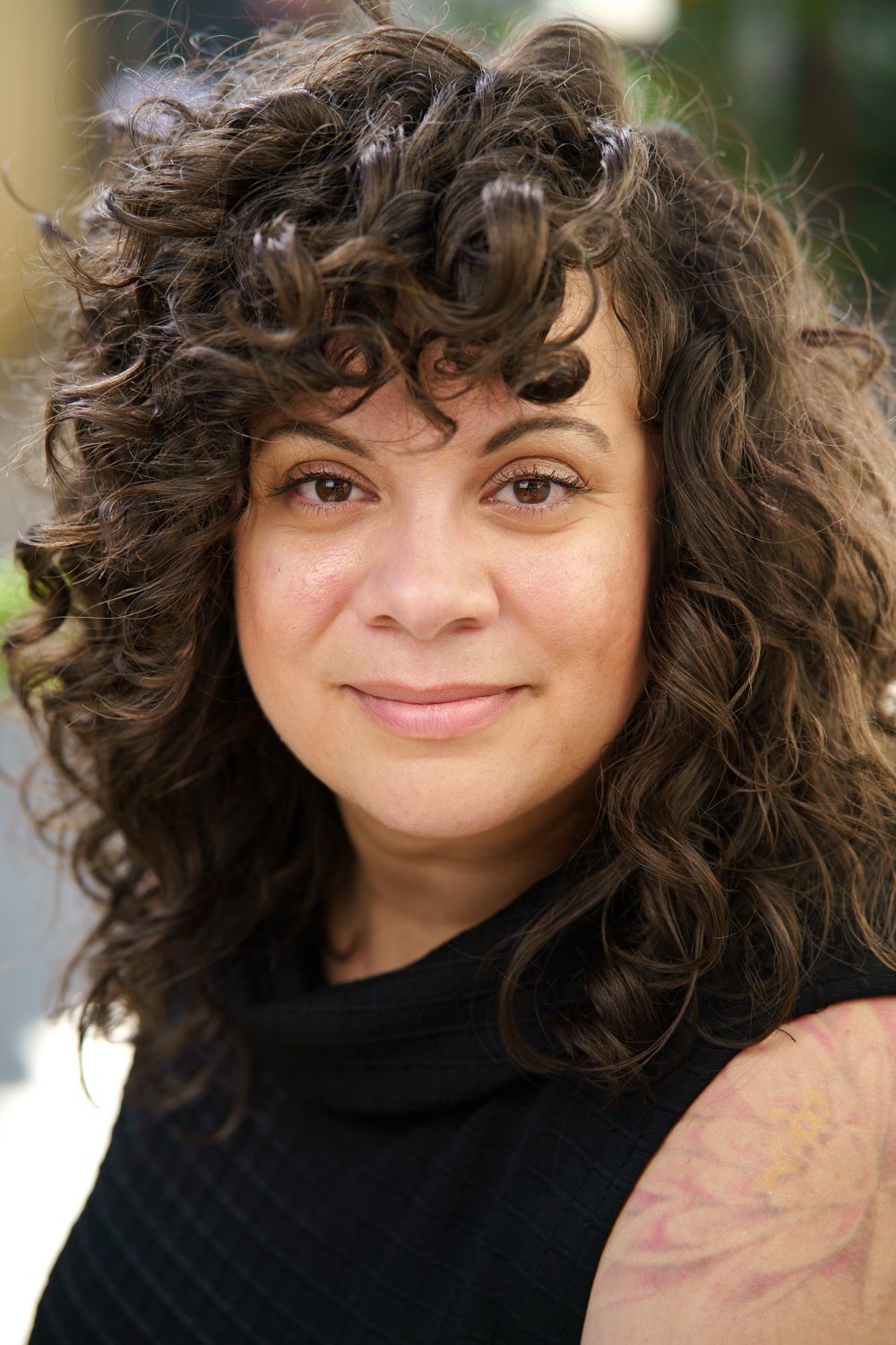 close up portrait of a mixed race smiling woman with curly brown hair