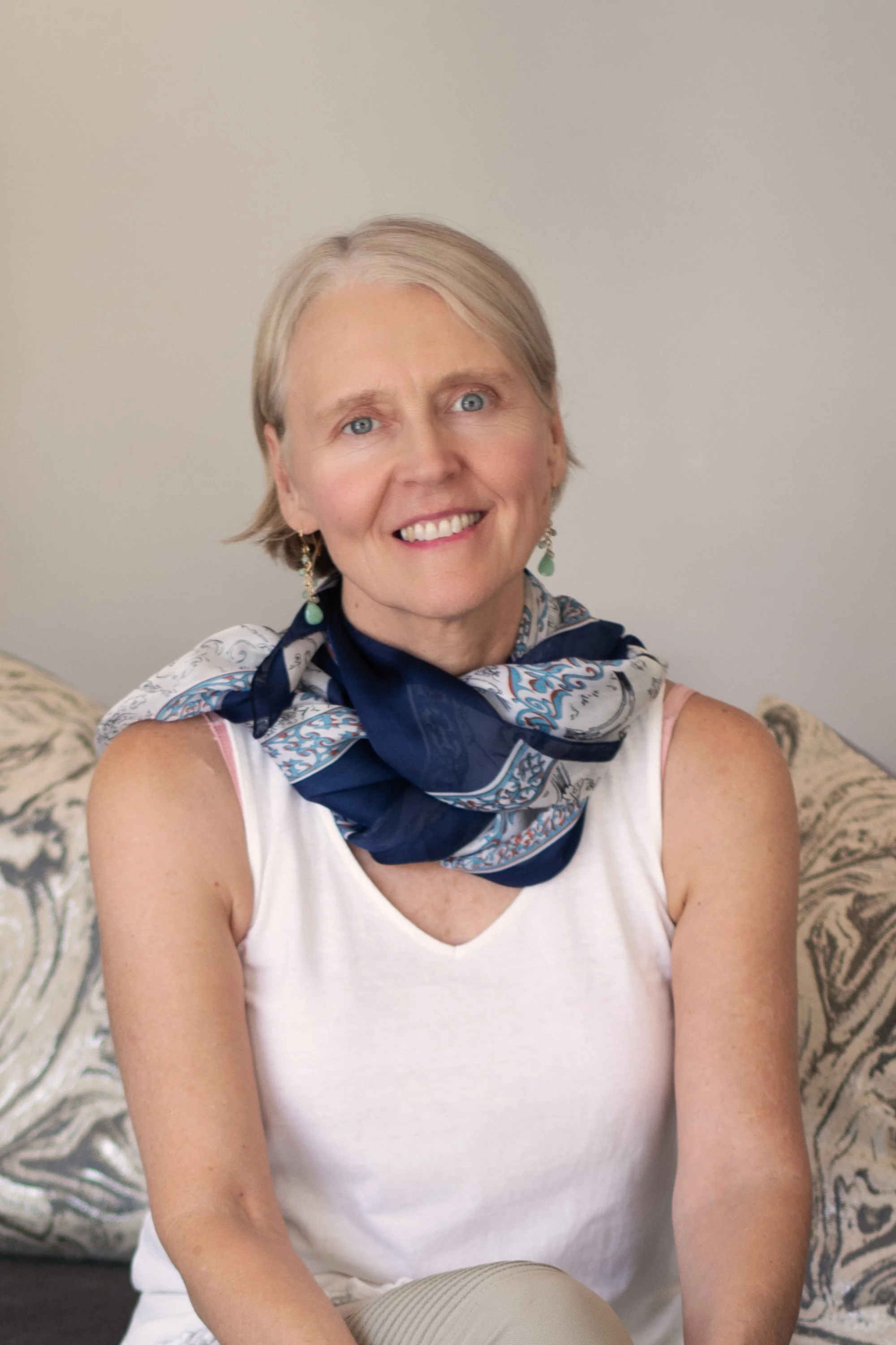 Rebecca Saxon, a transformational life coach, sitting on a sofa