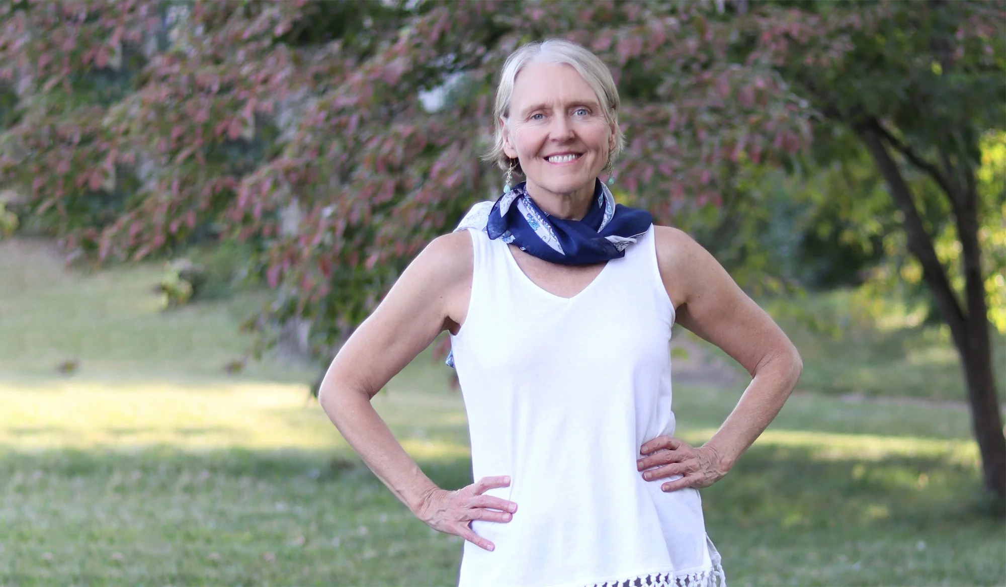 Transformational life coach Rebecca Saxon standing in nature with her hands on her hip