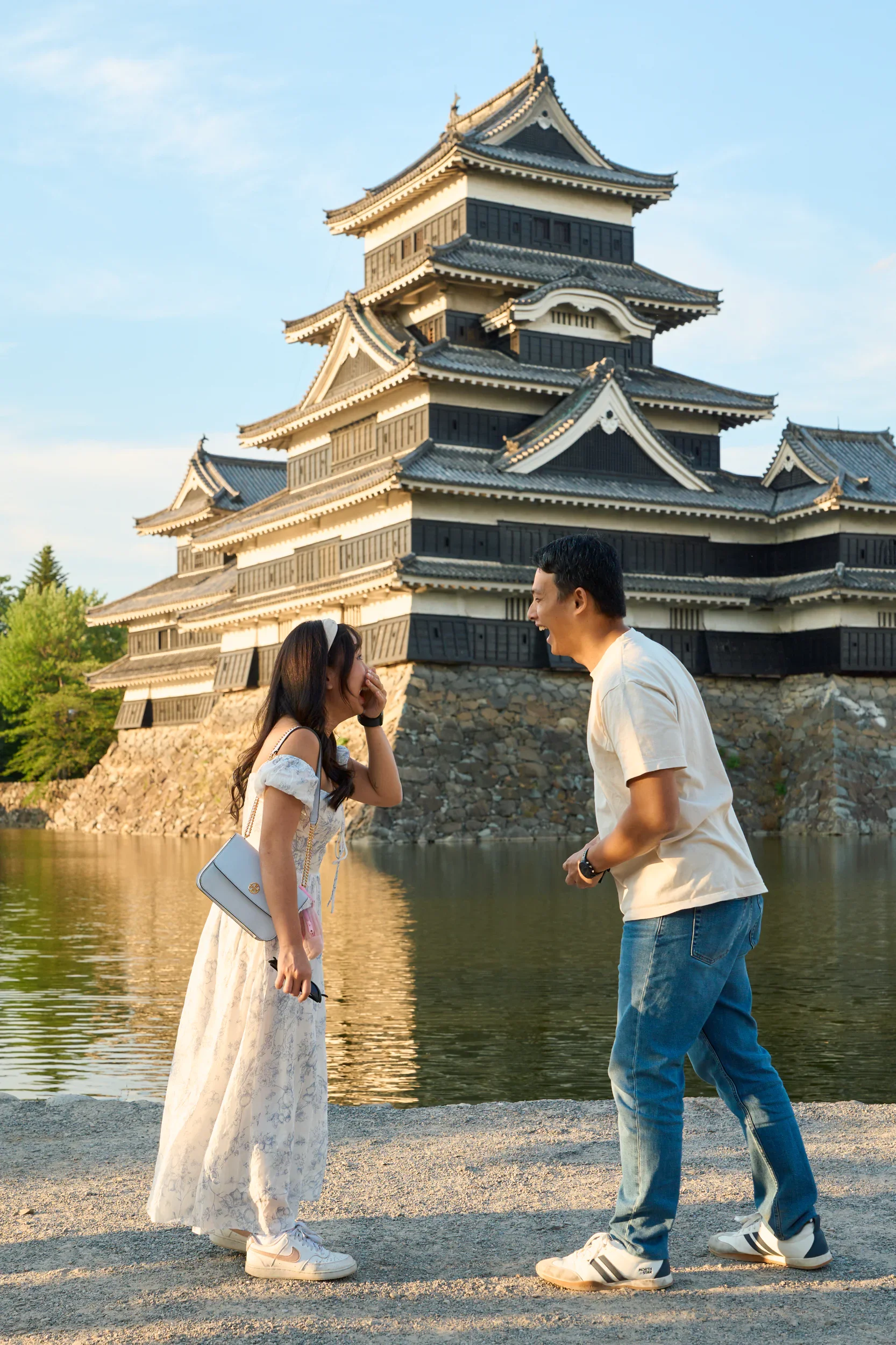 Couple facing each other in front of Matsumoto Castle moments before a surprise proposal