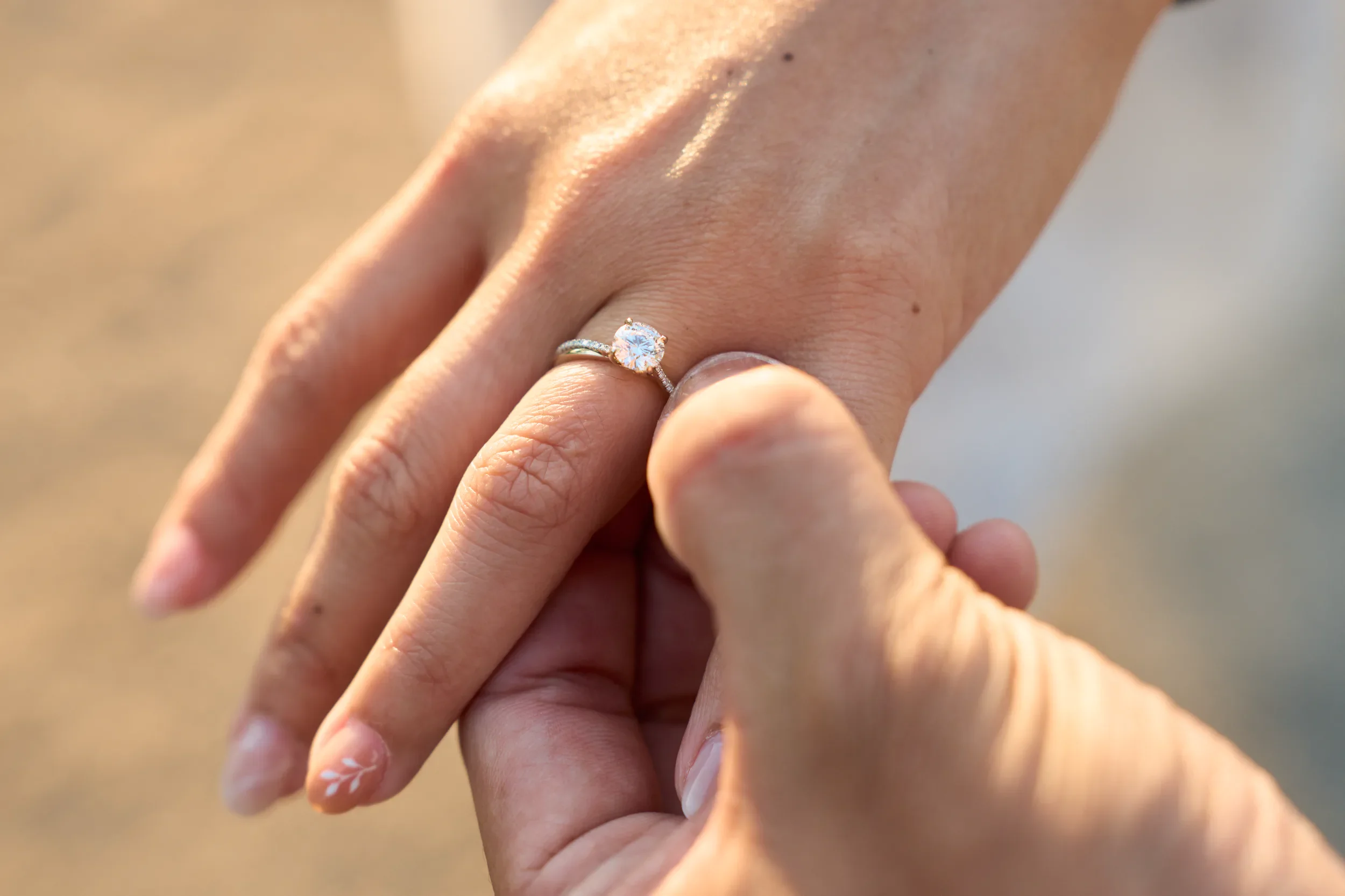 Close-up of an engagement ring on a hand outdoors in natural light