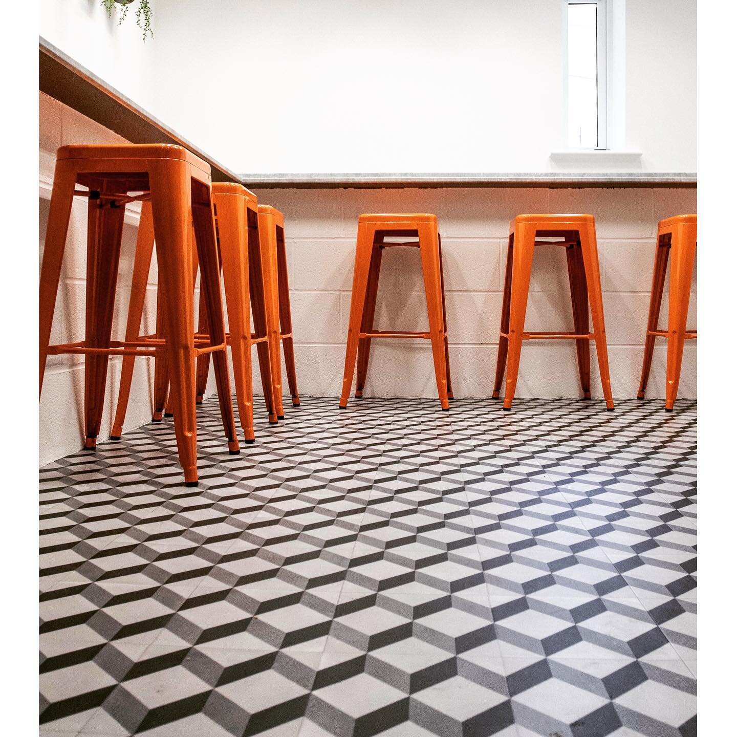 FLOORING// Fab geometric flooring from @tarkettuk with classic Tolix style stools from @cultfurniture - in the company&rsquo;s corporate colour, in this office kitchen and casual dining space.
The orange colour was throughout, linking each space and 