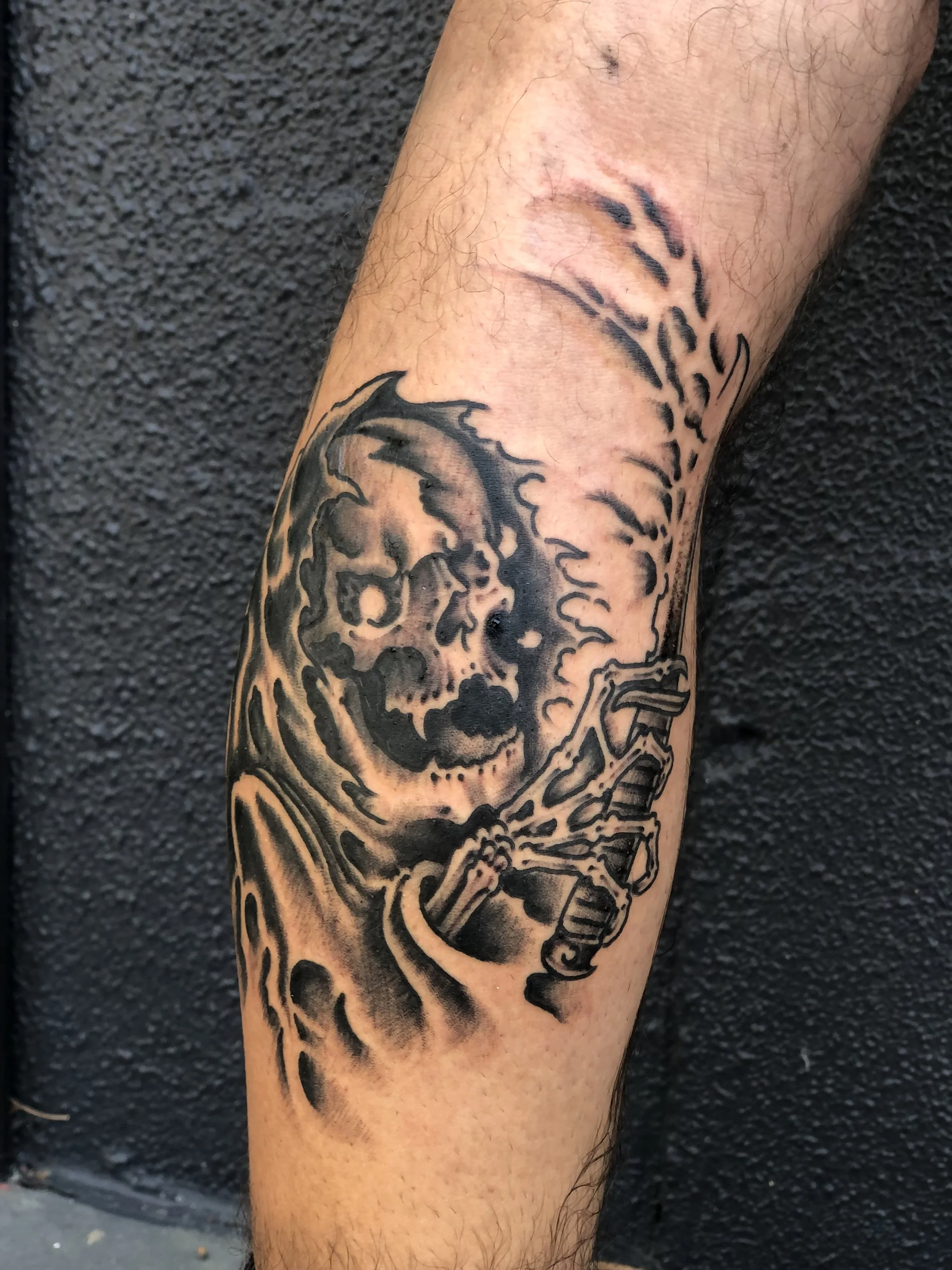 Tattoo of a grim reaper with a skeletal face and a scythe, made at Thanks Tattoo