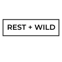 A rectangular sign with the text 'REST + WILD' in black letters on a white background.