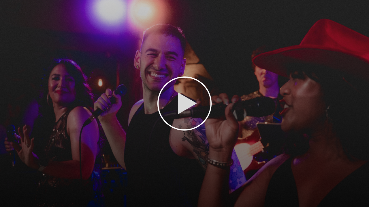 Stephen Scaccia and the Pride Band performing a high-energy live show sizzle reel with backup vocalists and colorful stage lights.