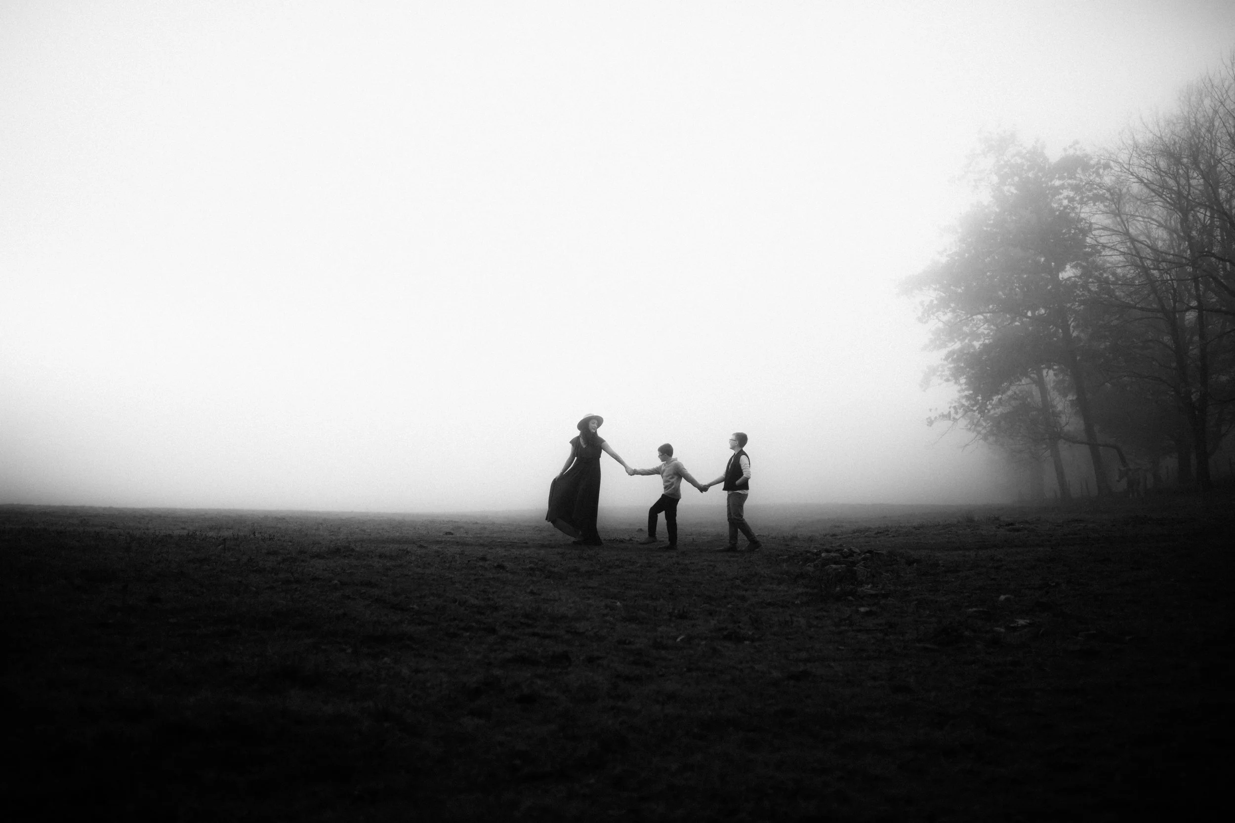 Lauren Dragon walking hand in hand with her two sons in a misty field