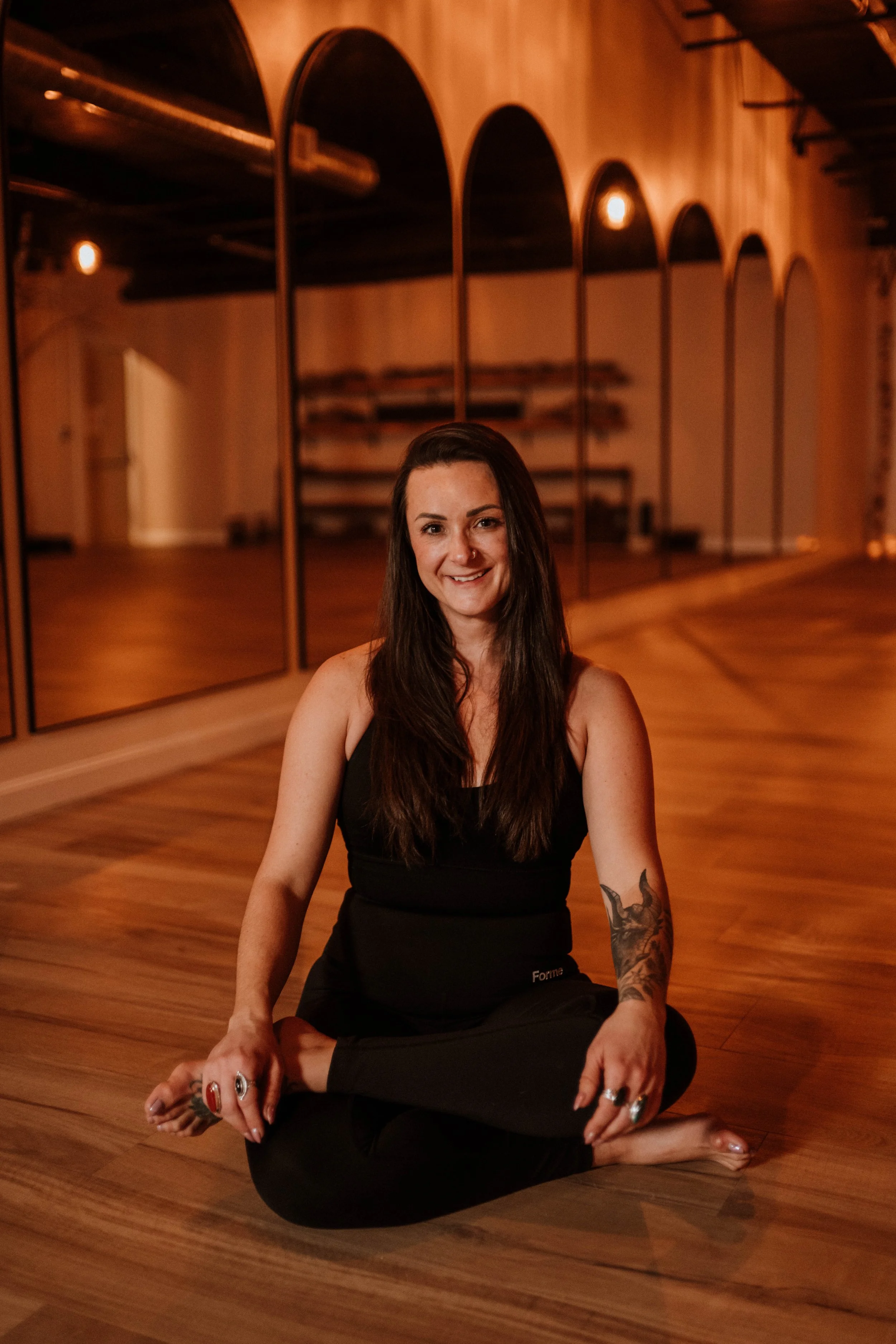 Lauren Dragon, holistic healing and alignment strategist, seated on a studio floor