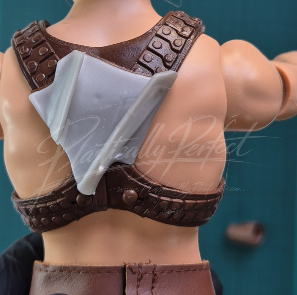 The chest piece, as seen from the back, with a plastic sword scabbard.  Also featured are the snaps, which are surprisingly easy to work with, to remove the chest piece from the doll.