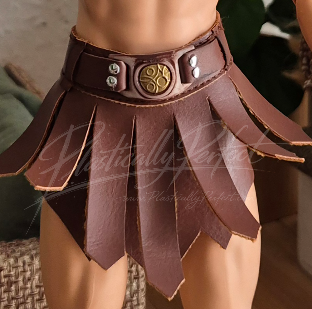 A close up shot of the skirt portion of the He-Man Ken doll’s costume. The leatherwork is fabric this time and it looks nice, though the faux metal detailing looks very plastic.