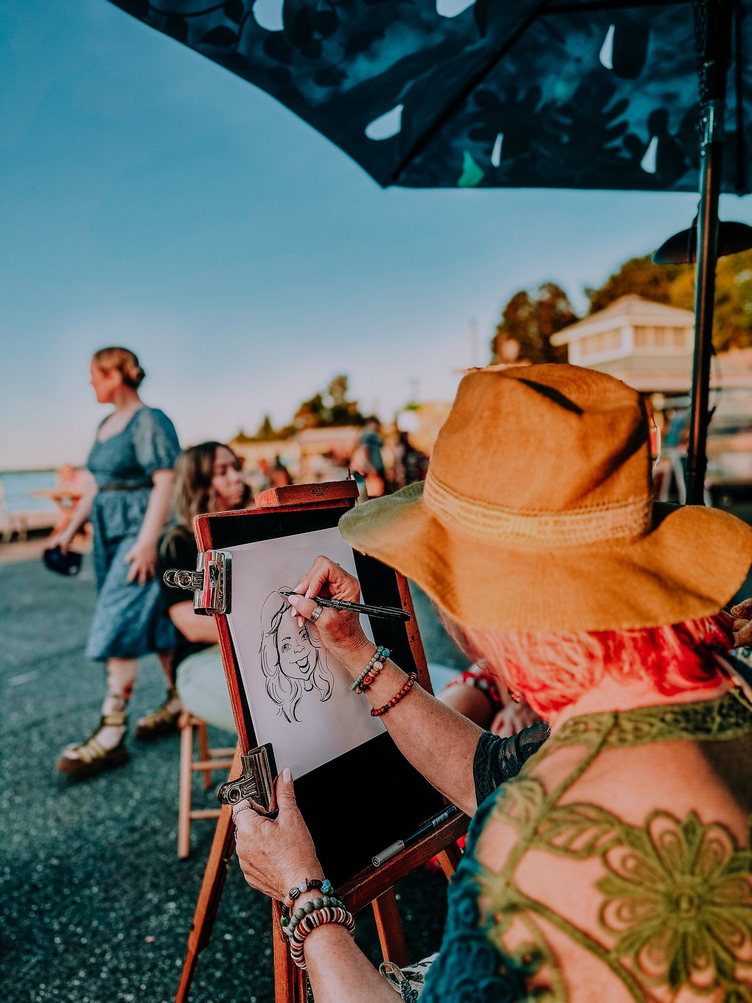 People relaxing and swimming at Scenic Beach Sate Park in Seabeck with mountains and Hod Canal in the background.