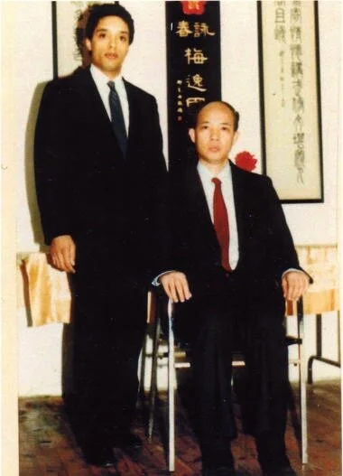 Grandmaster Moy Tung standing beside his teacher, Grandmaster Moy Yat.