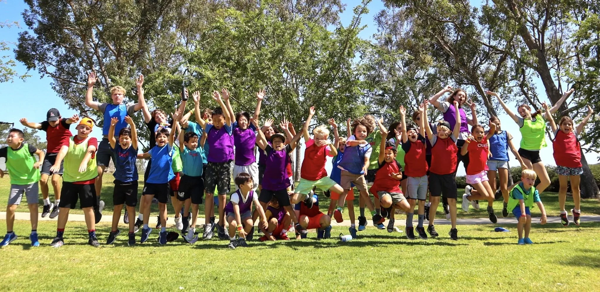 CORE summer campers cheering together and having fun outdoors.