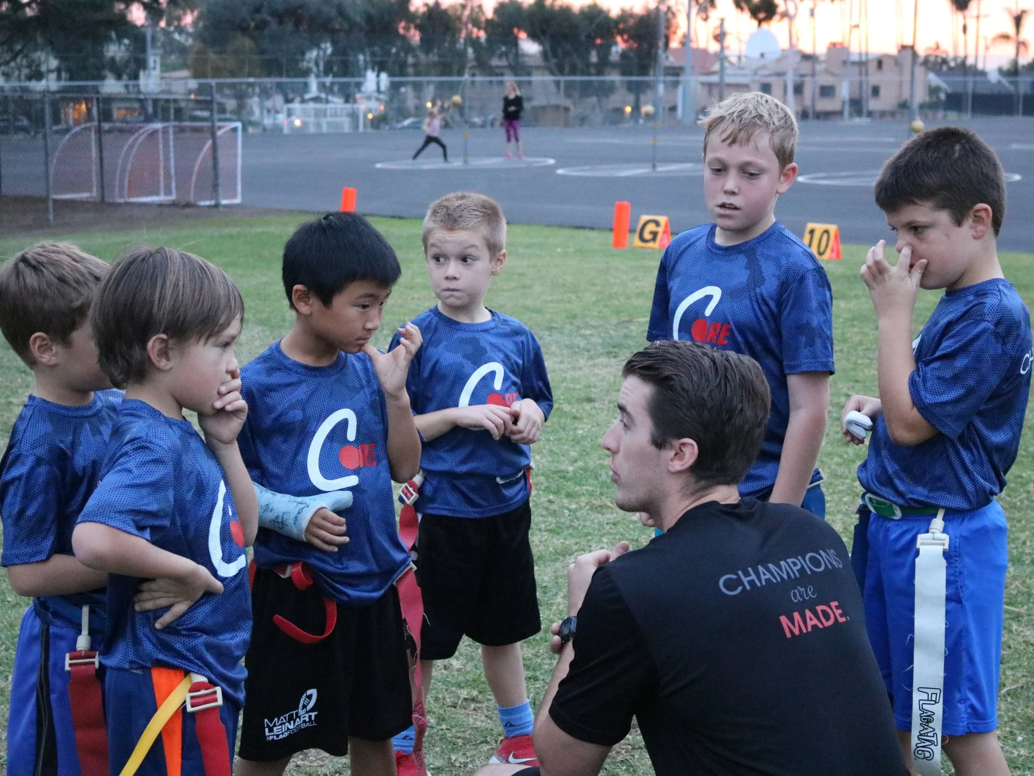 CORE coach leading a small group of kids during a youth sports activity.