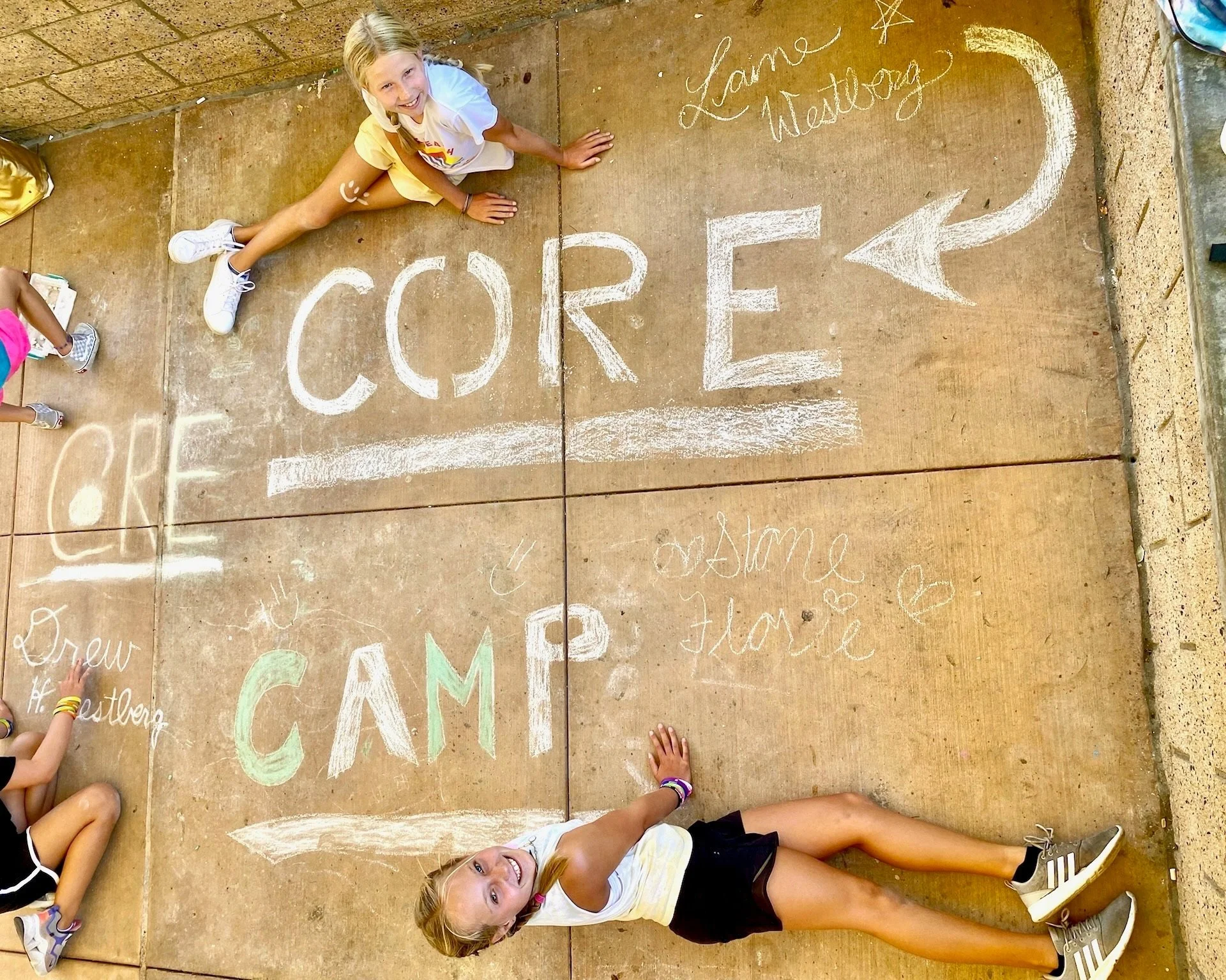 Summer campers drawing celebrating camp with chalk drawing.