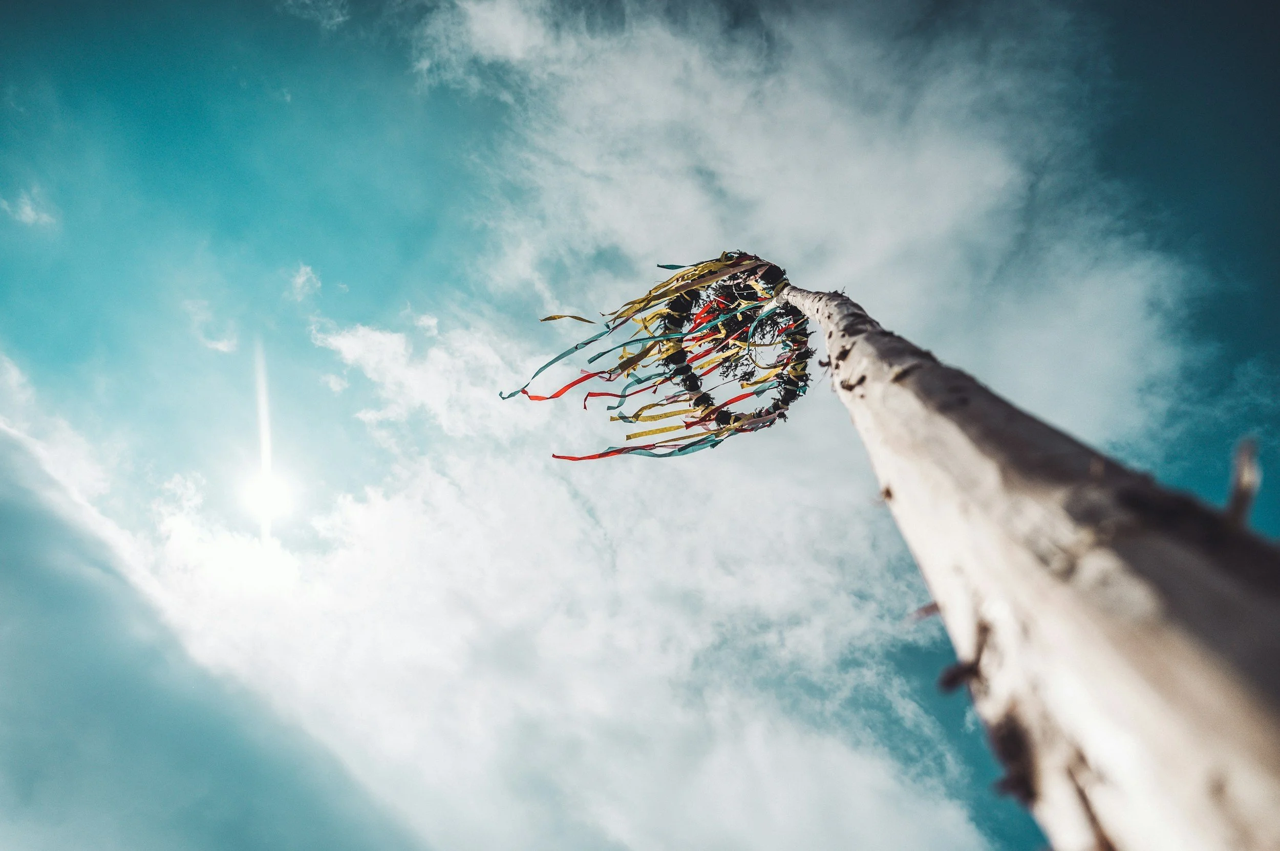 Picture of a Maypole against a blue sky for May traditions and rituals