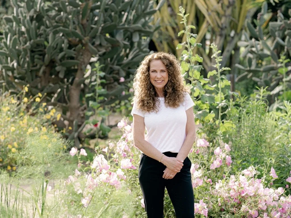 Jeanine Mouchawar, Parenting Coach, standing in a flower garden.