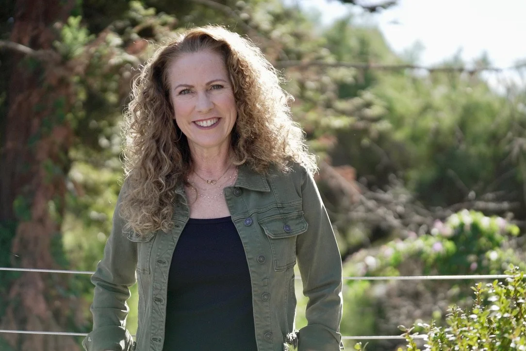 Parenting coach Jeanine Mouchawar standing outdoors in a green jacket, helping parents understand why parenting teenagers feels so hard even when you're trying everything