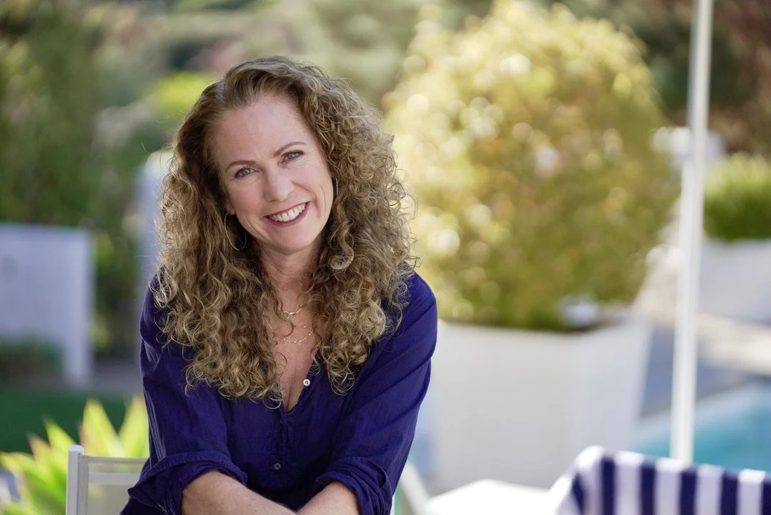 Parenting coach smiling outdoors, representing emotional support for parents feeling disconnected from their teenagers and struggling with communication and relationship challenges.