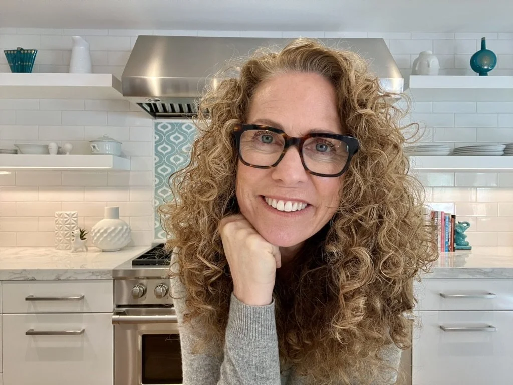 Parent coach Jeanine Mouchawar smiling in her kitchen, accompanying an article about knowing when to step in and when to let a teenager figure things out independently.