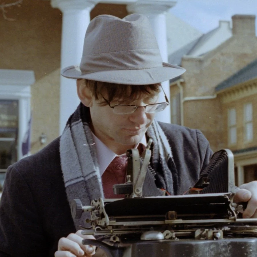 Joseph Jablonski typing in downtown Winchester, Virginia in a photo taken by Sam Cutler Photography.