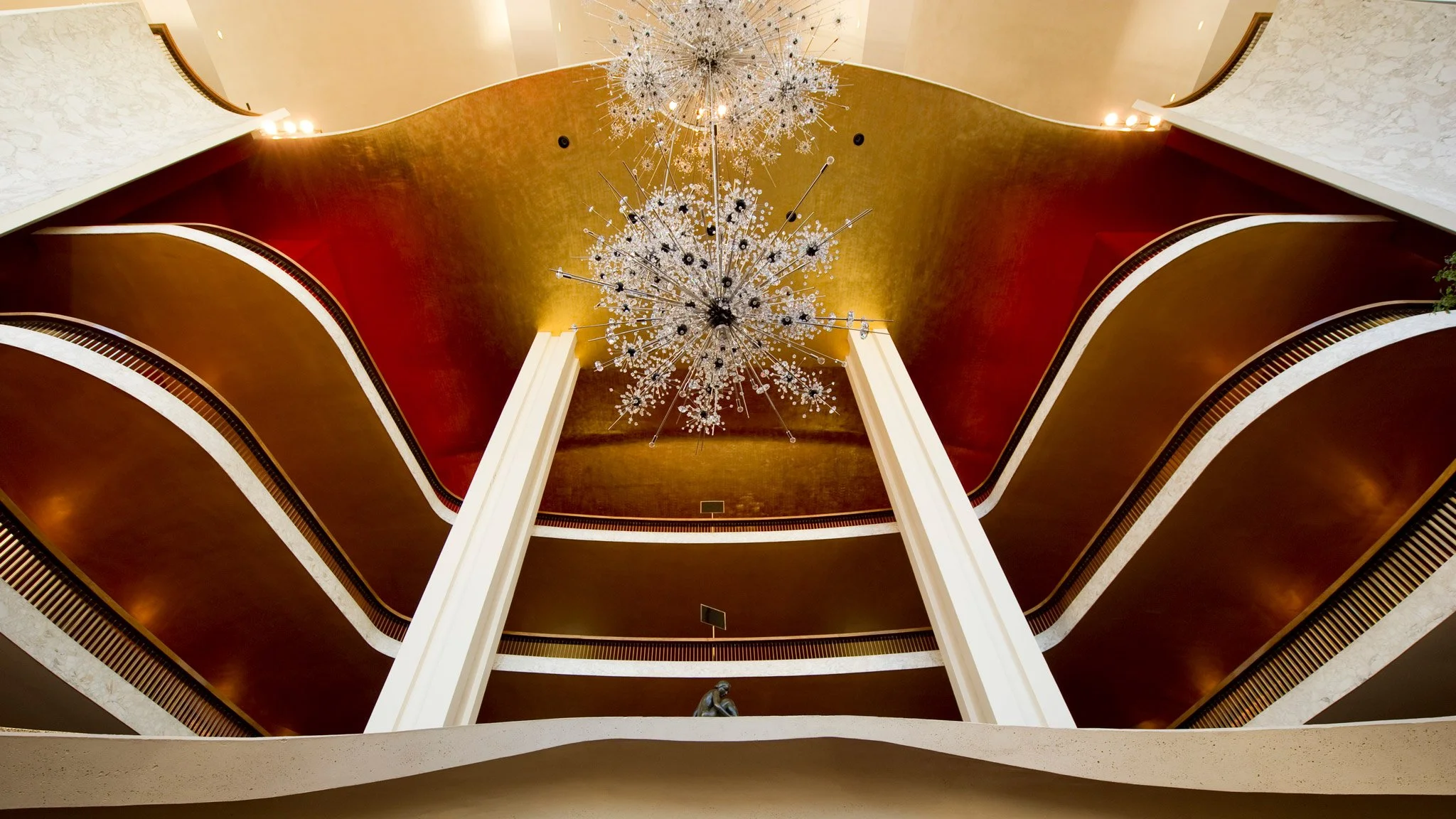 Night view of Chicago skyline featuring the Cloud Gate sculpture in Millennium Park, with illuminated skyscrapers including the Prudential building and others in the background.