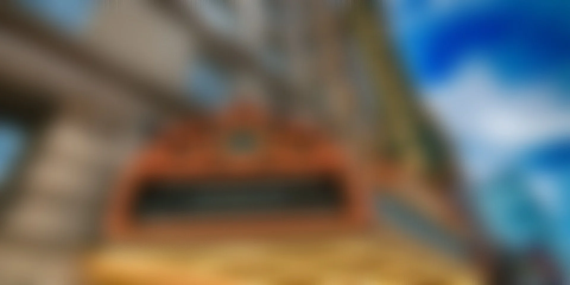 Nighttime cityscape with illuminated skyscrapers, highways with streaks of light from moving vehicles, and trees in the foreground.