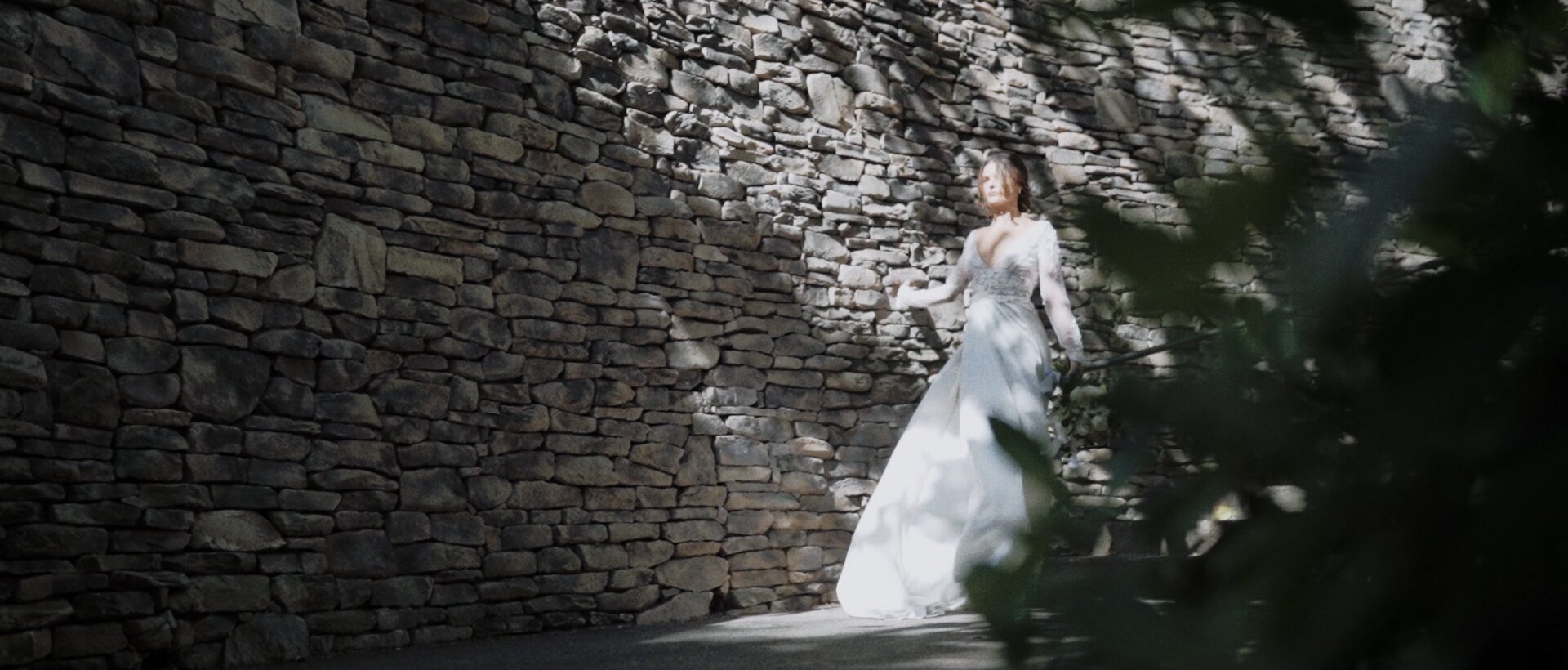 bride walking by Montage Kapalua stone wall