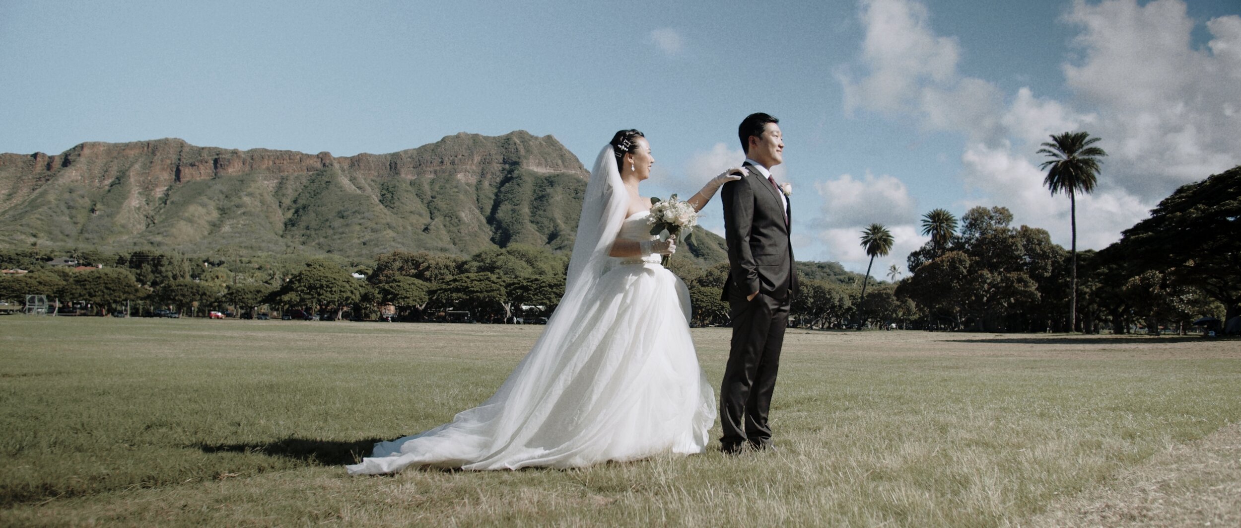 bride and groom with hawaiian mountain in the background