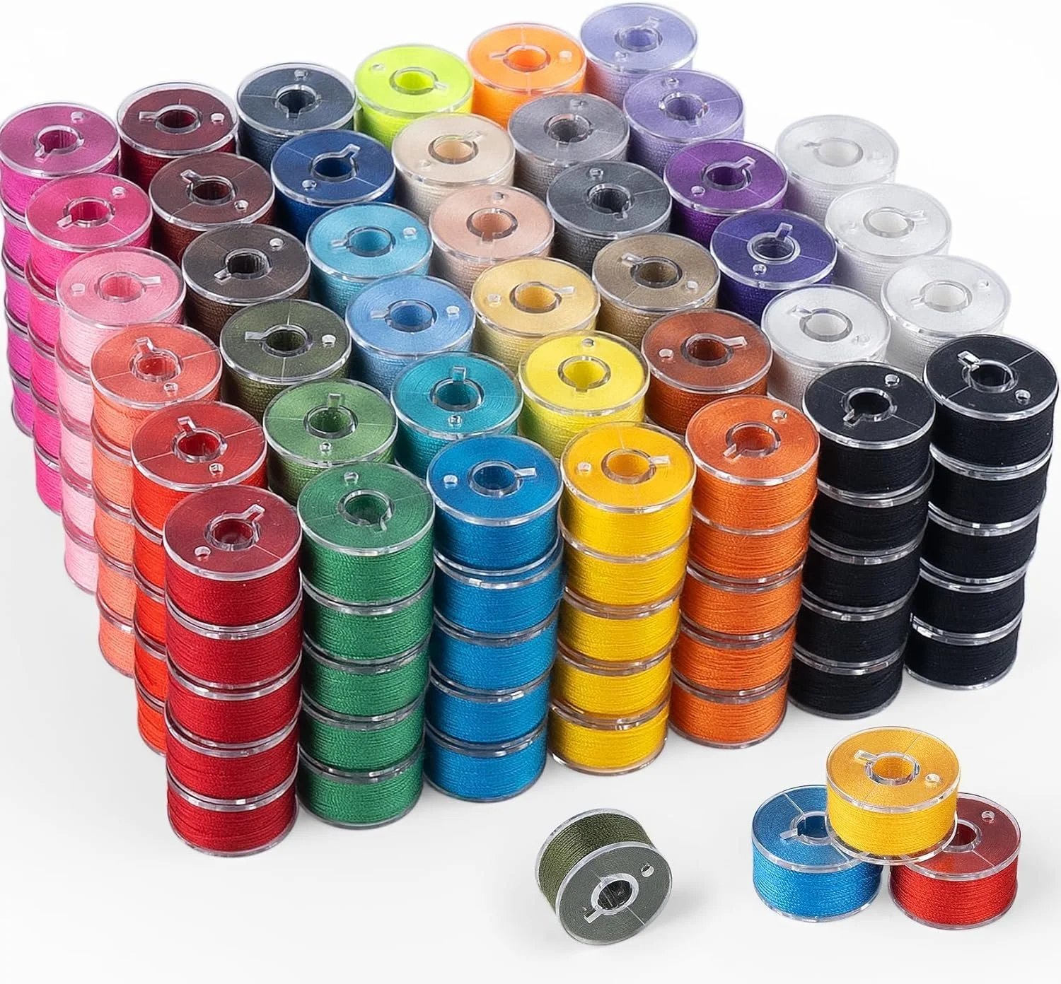 Stacks of colorful sewing threads arranged in rows and some loose spools on a white background.