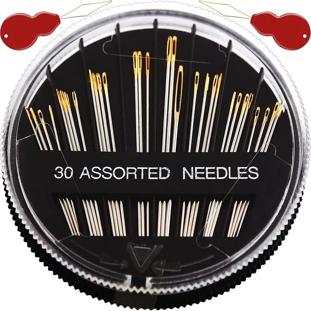 A round container with a clear lid holding 30 assorted sewing needles arranged vertically, with a label that reads "30 ASSORTED NEEDLES." The container has a black and silver design, and there are two red pincushion illustrations on the top of the lid.