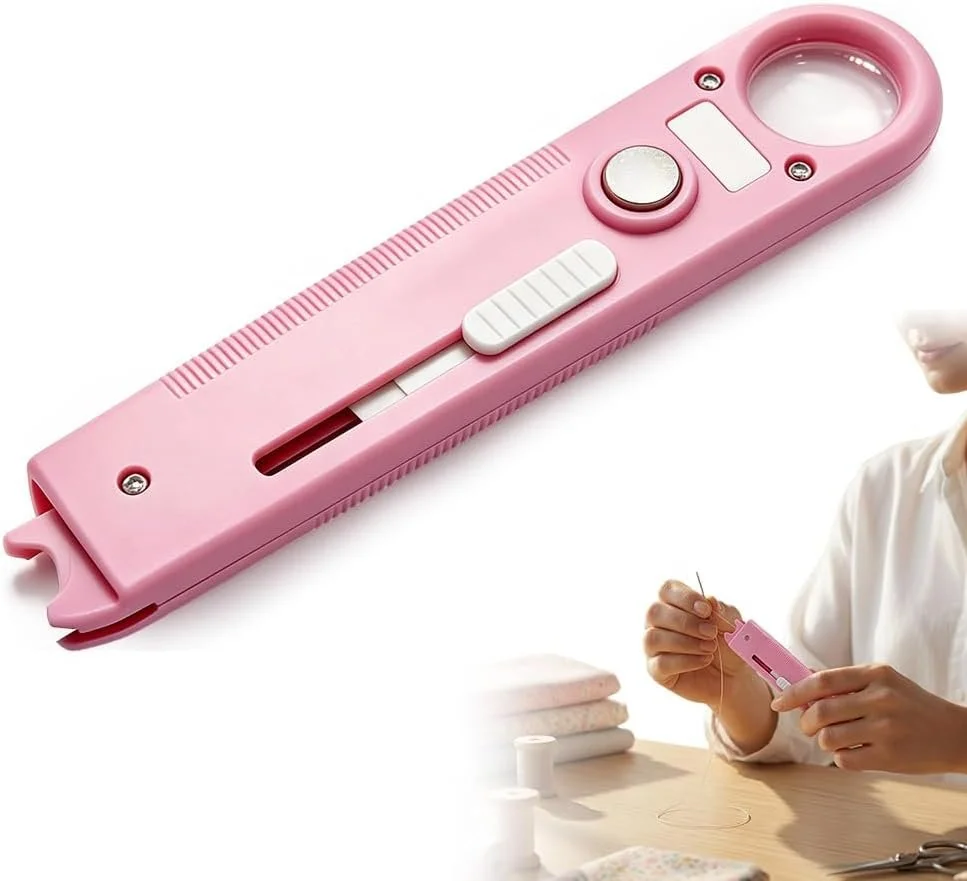 Close-up of a pink sewing machine with a circular magnifying glass on top, a white switch, a white dial, and a sliding button on the side, used for embroidery or sewing.