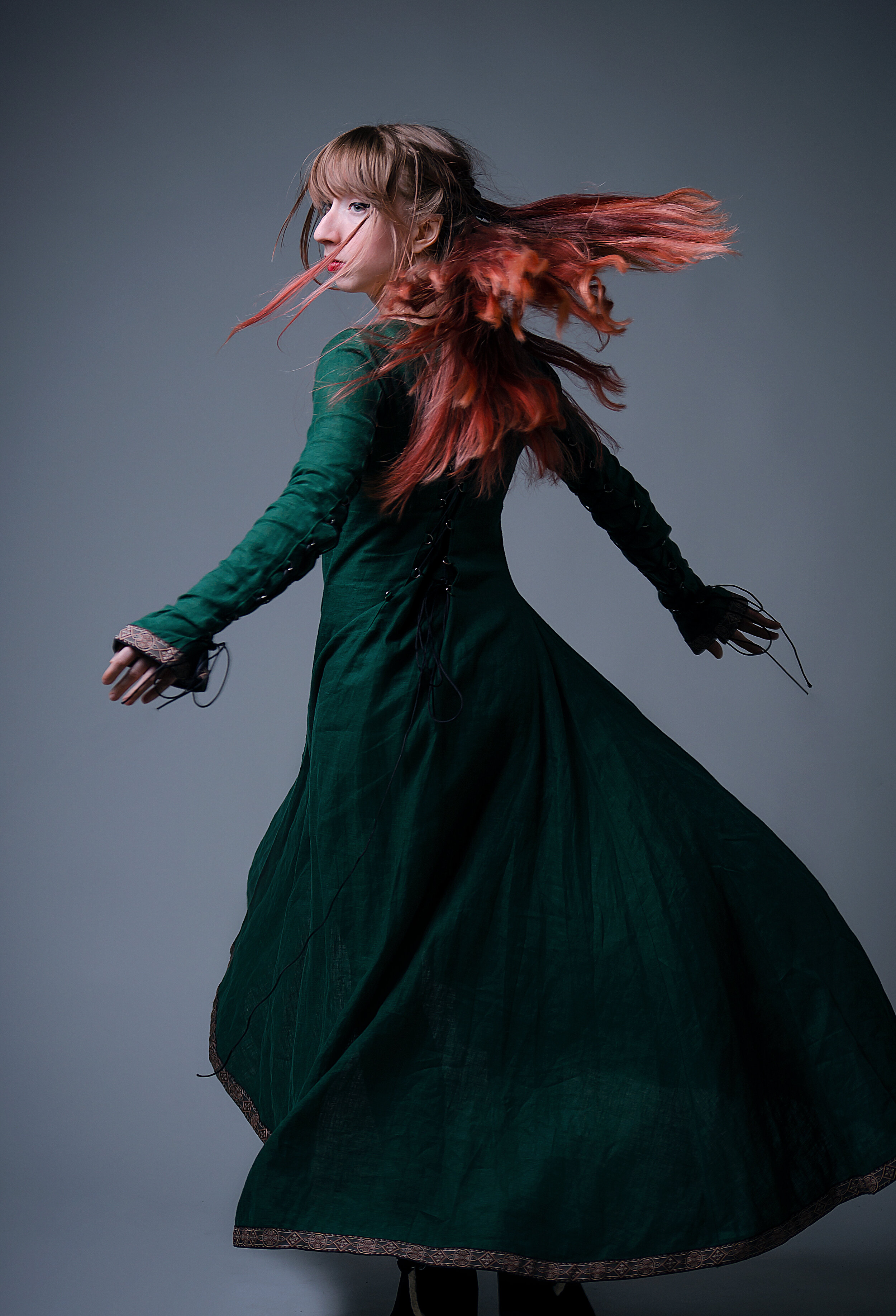 Redhead girl spinning in the long dress