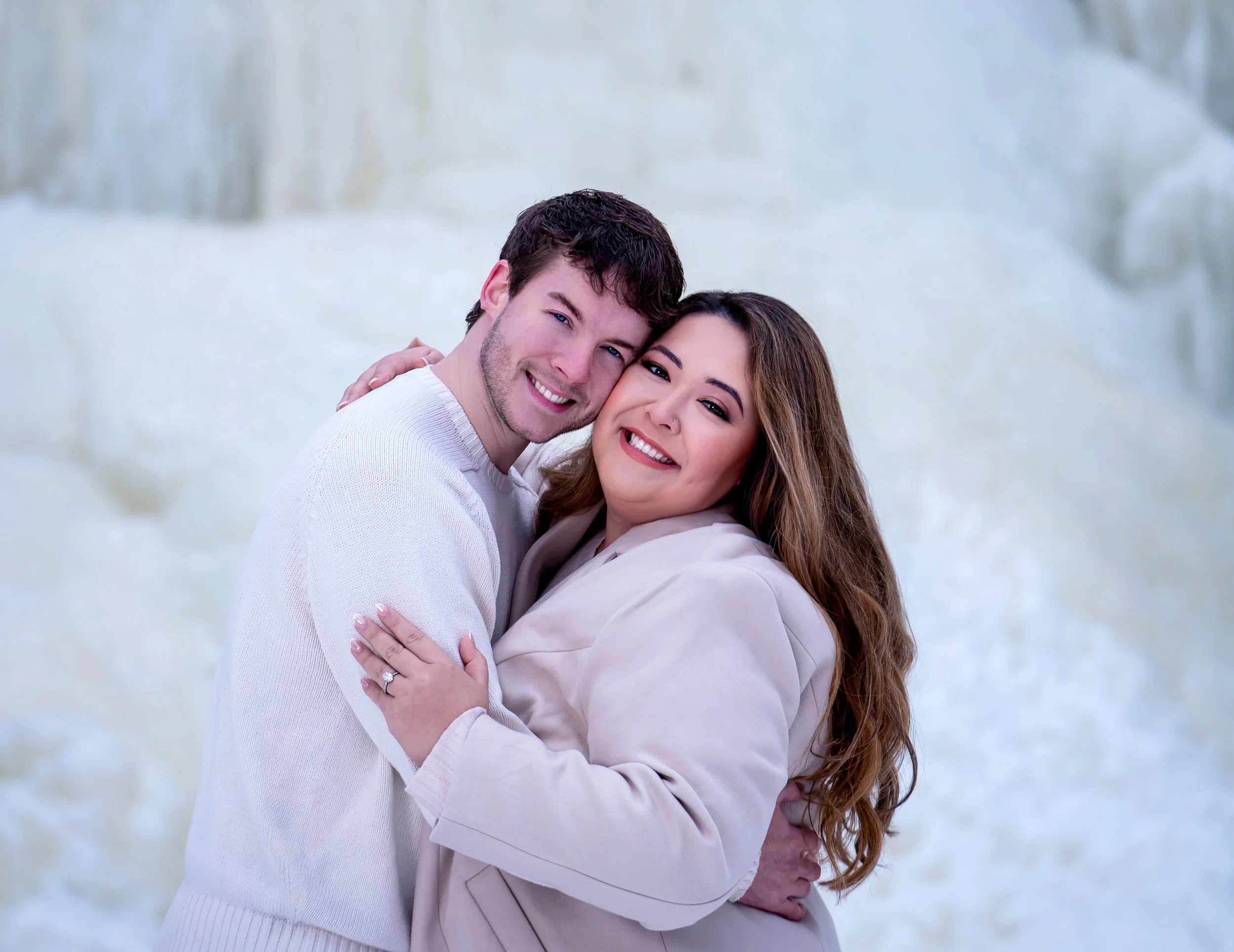 Romantic winter engagement photos of a couple near frozen Wequiock Falls in Green Bay, Wisconsin, surrounded by dramatic ice formations.