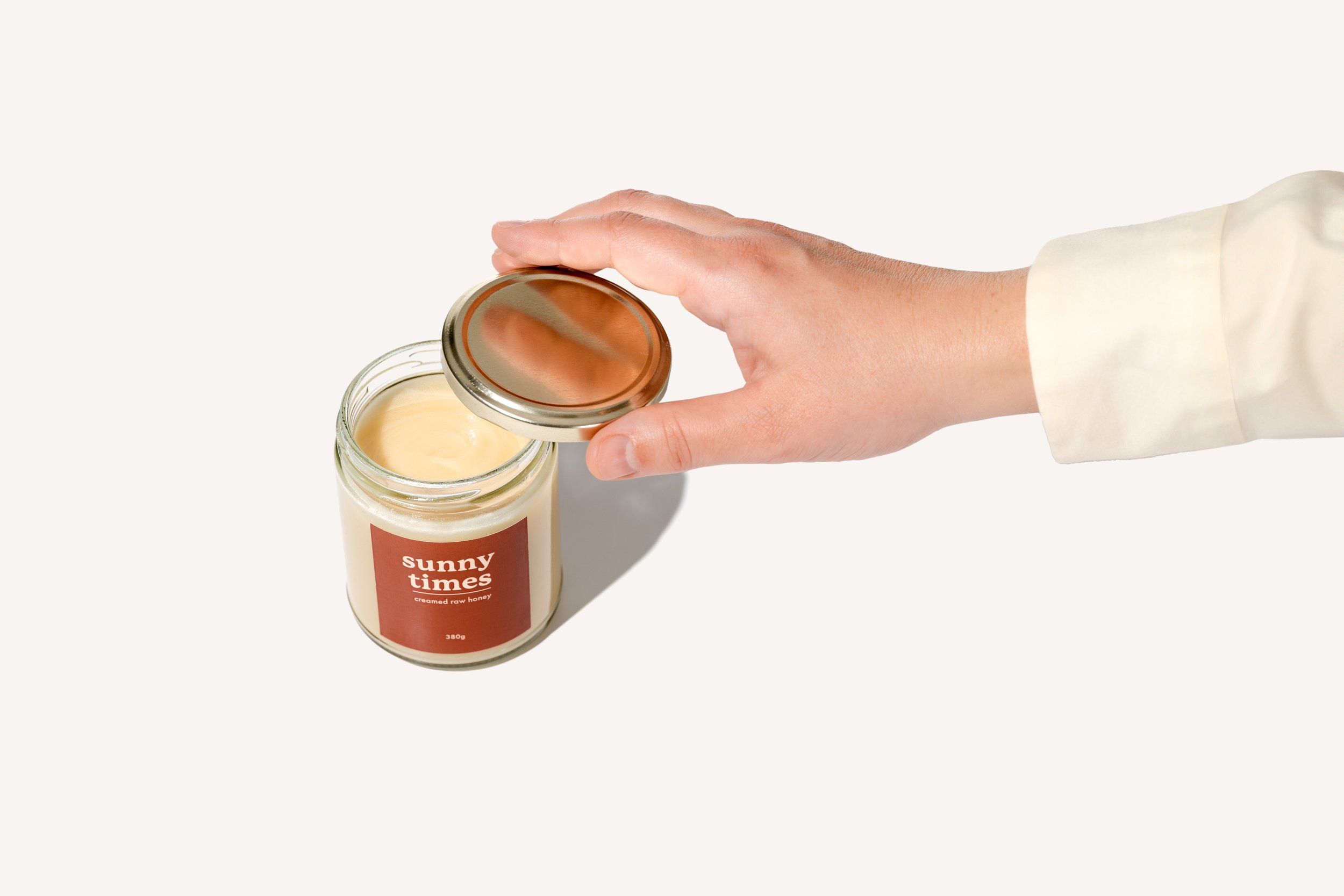 Jar of Sunny Times Certified Organic raw creamed honey, jar showing smooth, spreadable creamed honey