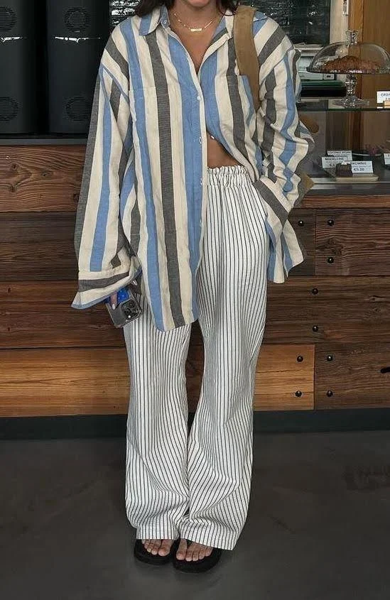 woman wearing beach outfit striped blue button down top and striped pants