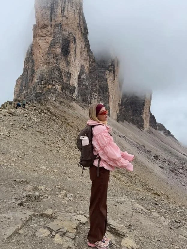 girl hiking mountain in cute pink rain jacket
