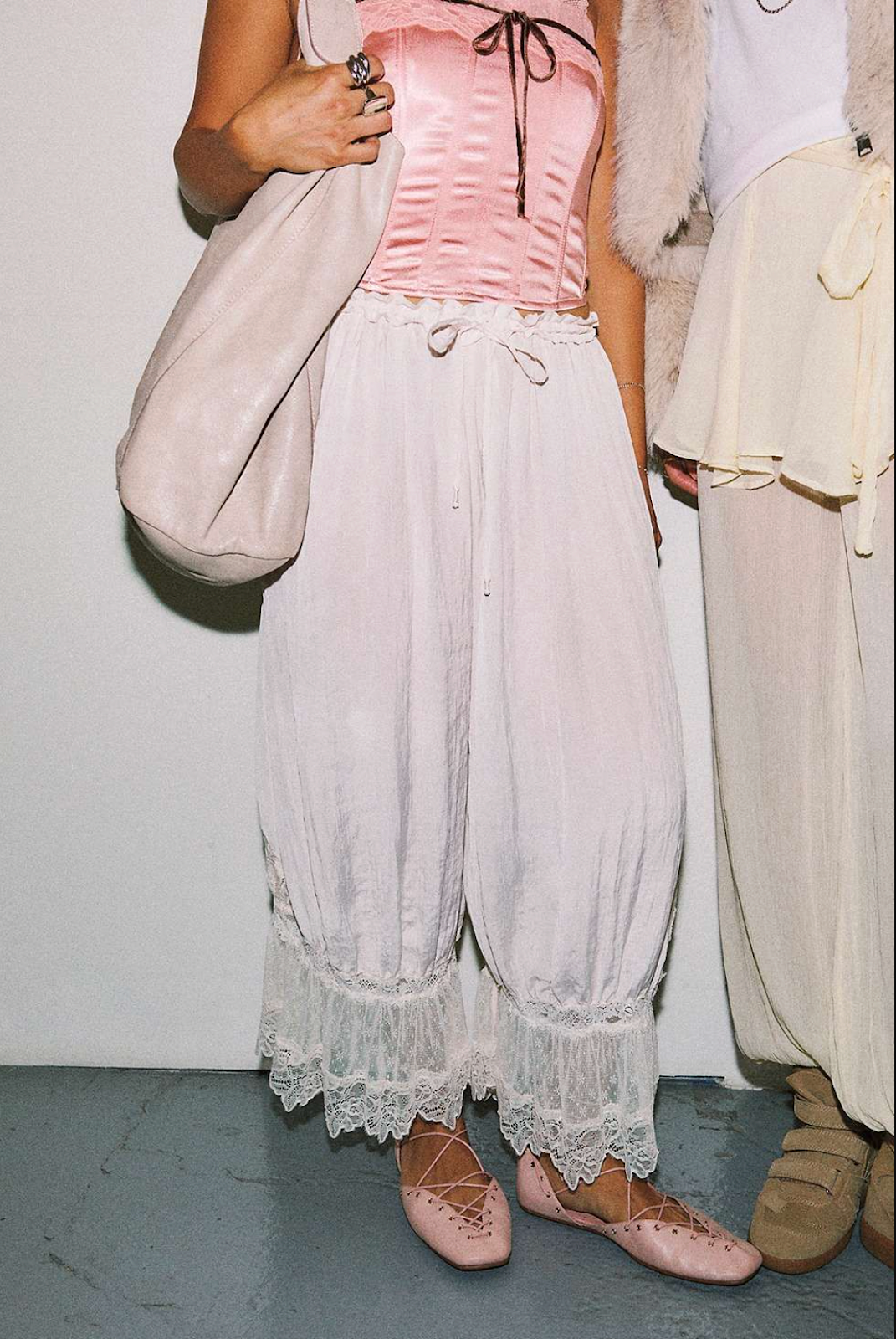 woman in pink corset and flowy white pants