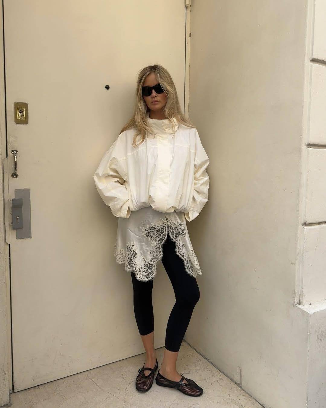 girl wearing white rain jacket and black capris