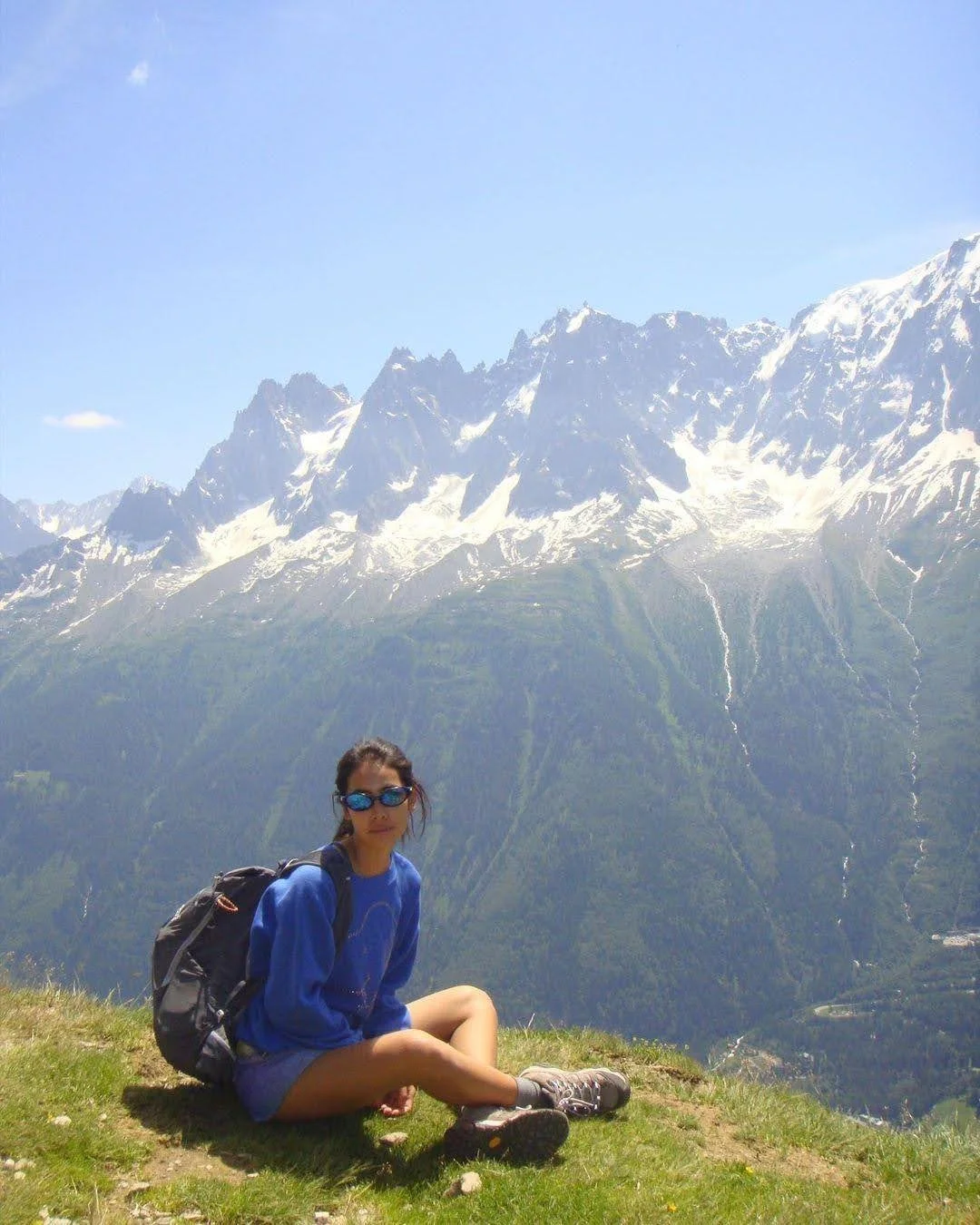 girl hiking in the mountains in blue outdoor jacket