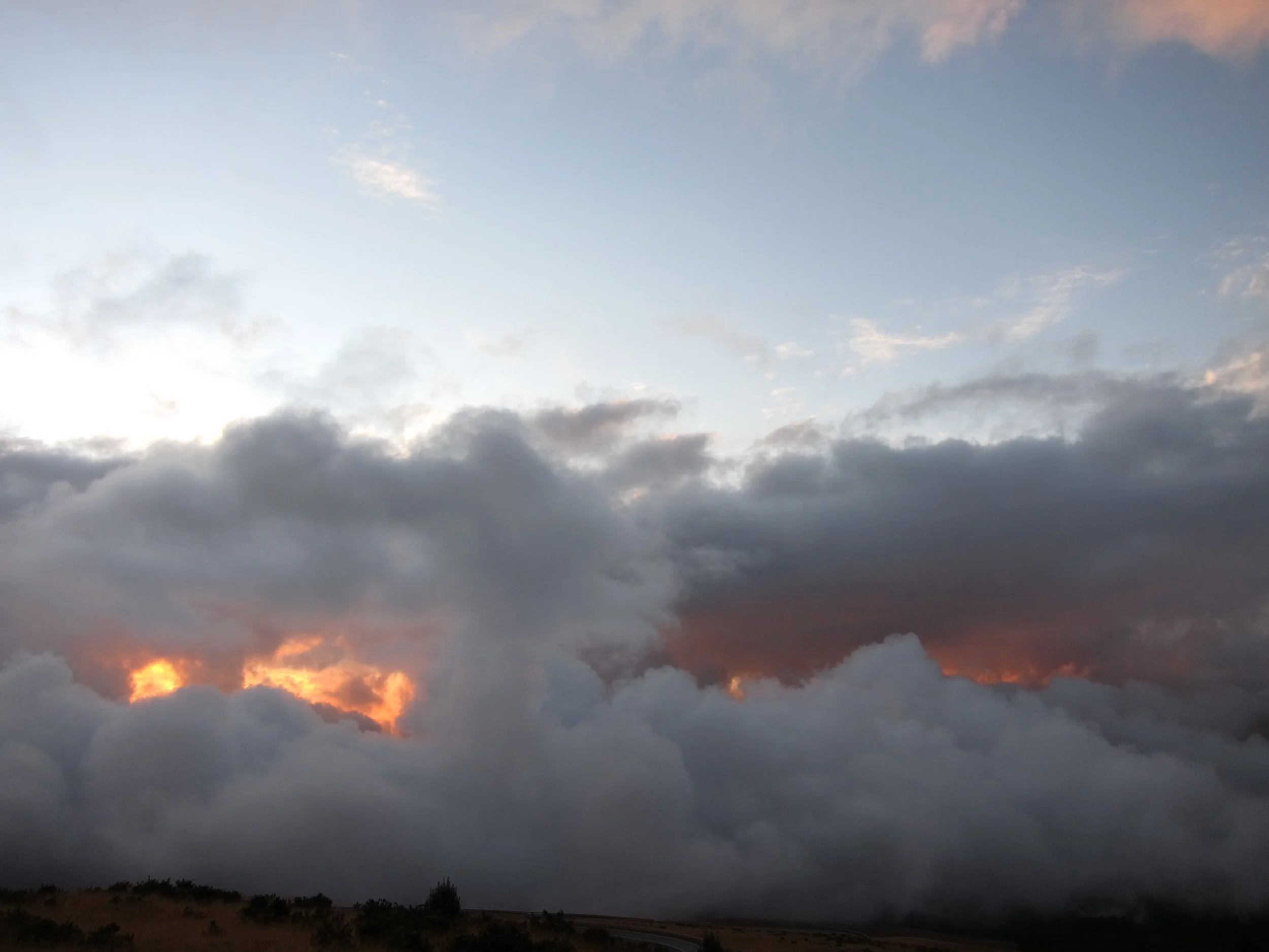 That's a cloud over sunshine from Mt. Haleakala. No fire nor lava here.