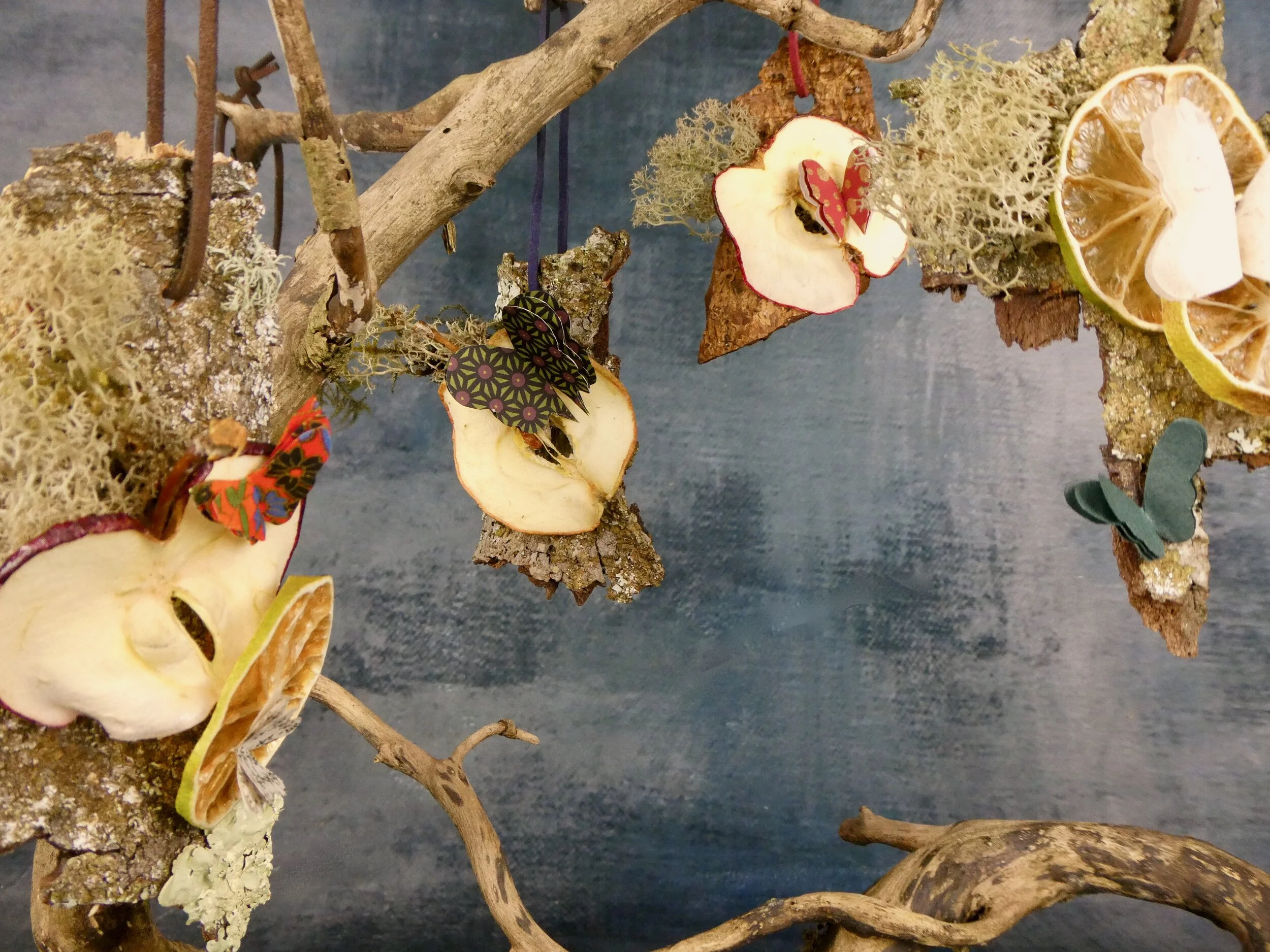 A selection of the decorations hung on a piece of ivy wood.