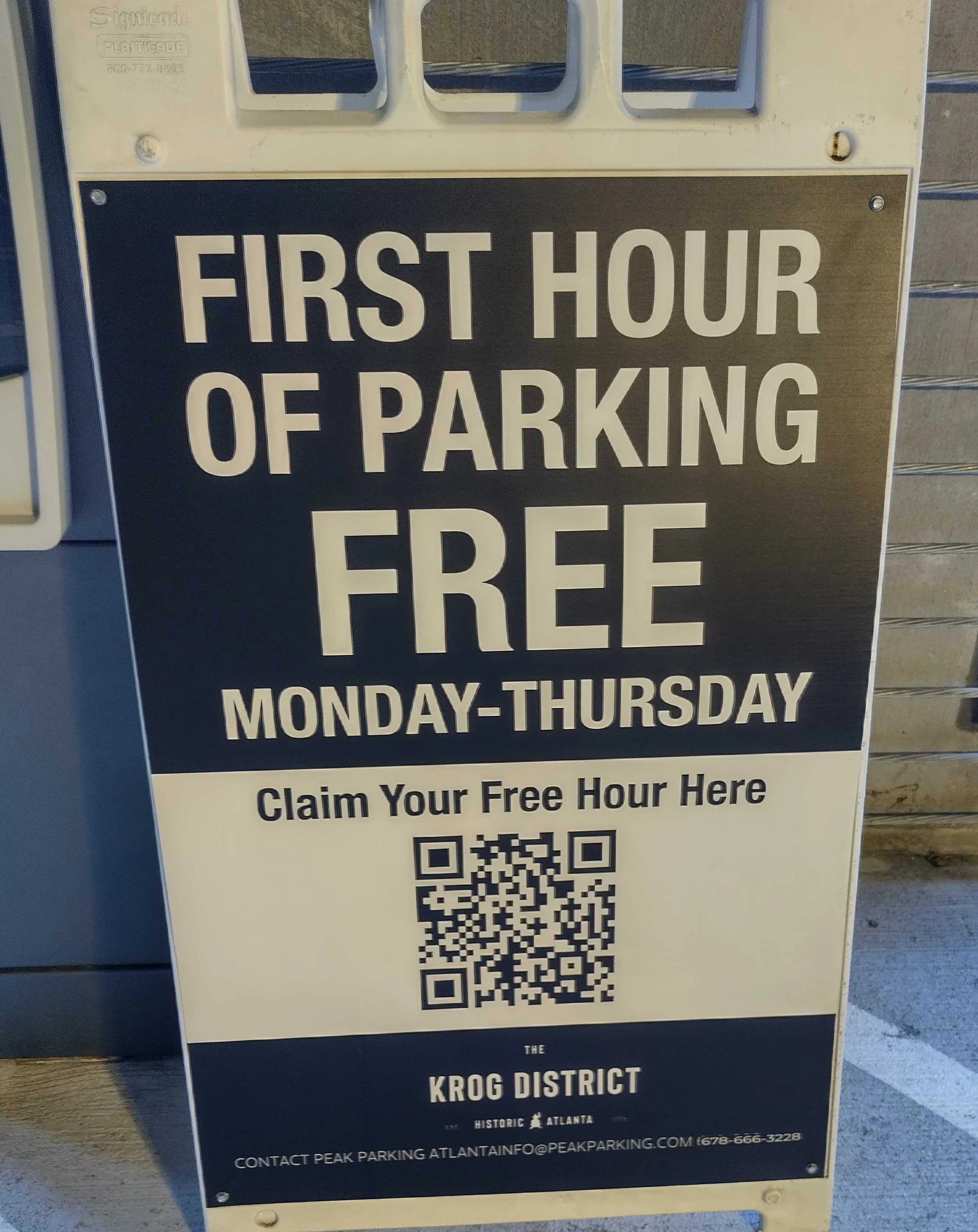 Sign advertising free parking for the first hour Monday through Thursday by scanning a QR code, located in the Krog District, Atlanta, Georgia.