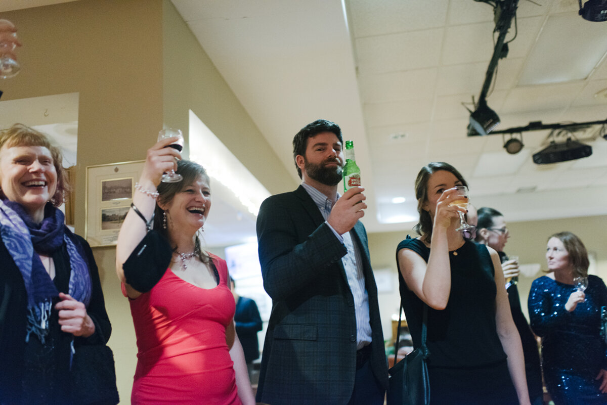 Guest holding up their glass in a toast to the bride and groom at Kingston Ontario wedding
